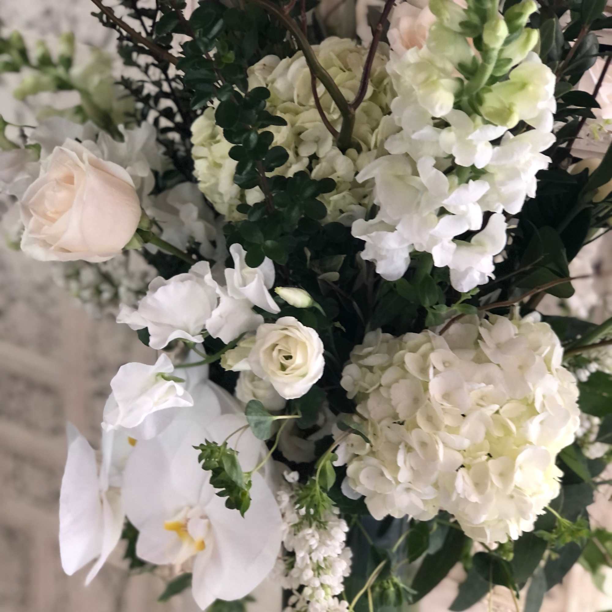 Gorgeous, tall arrangement with an assortment of white and cream garden flowers