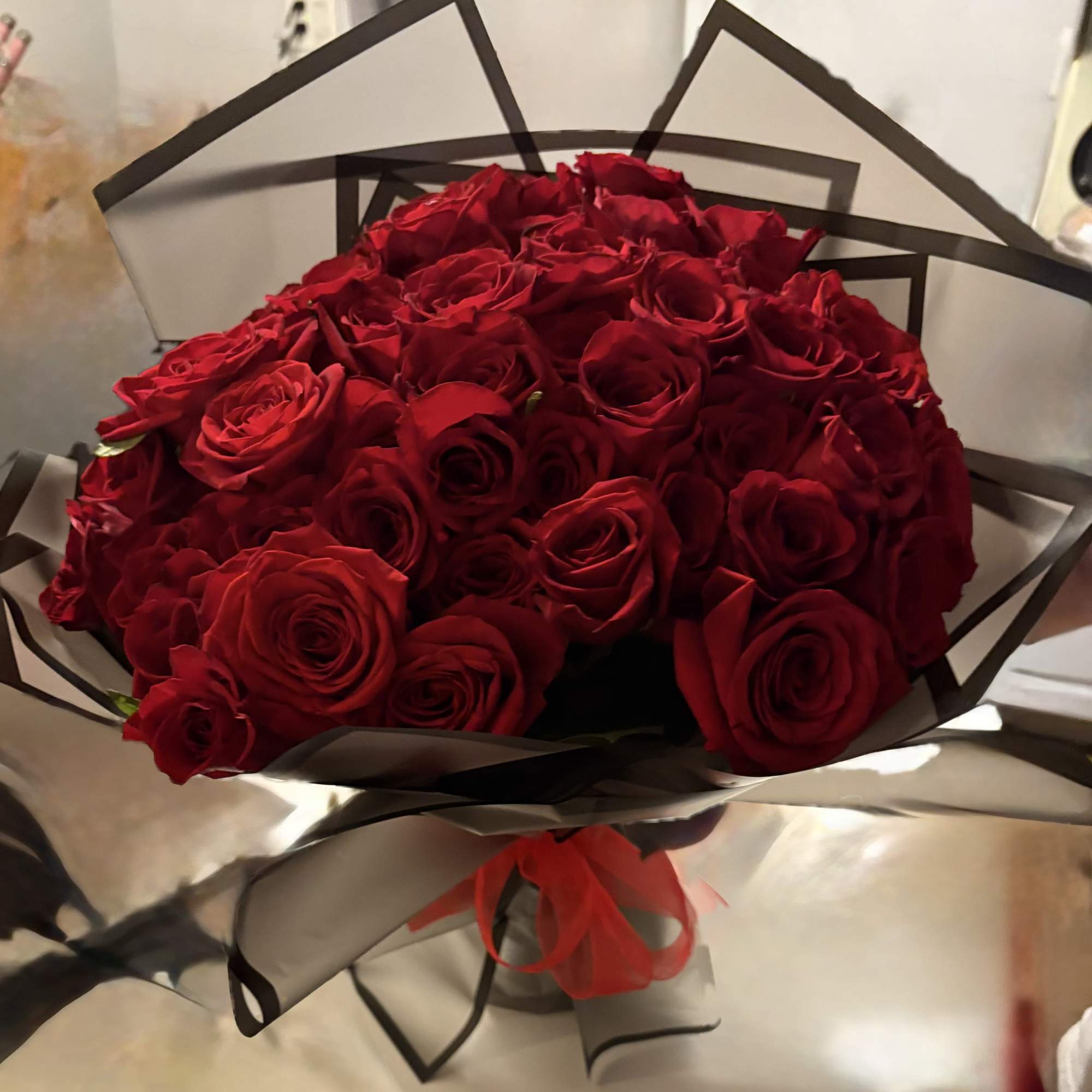 48 Hand tied roses wrapped in an elegant black craft paper tide