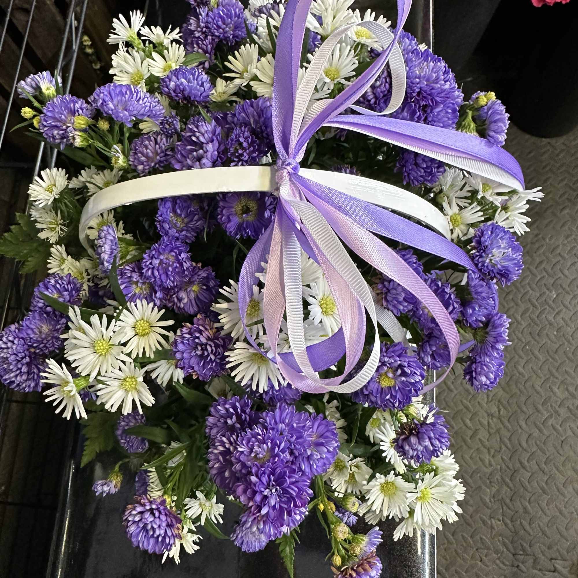 Purple and white fresh cut flowers in a white basket