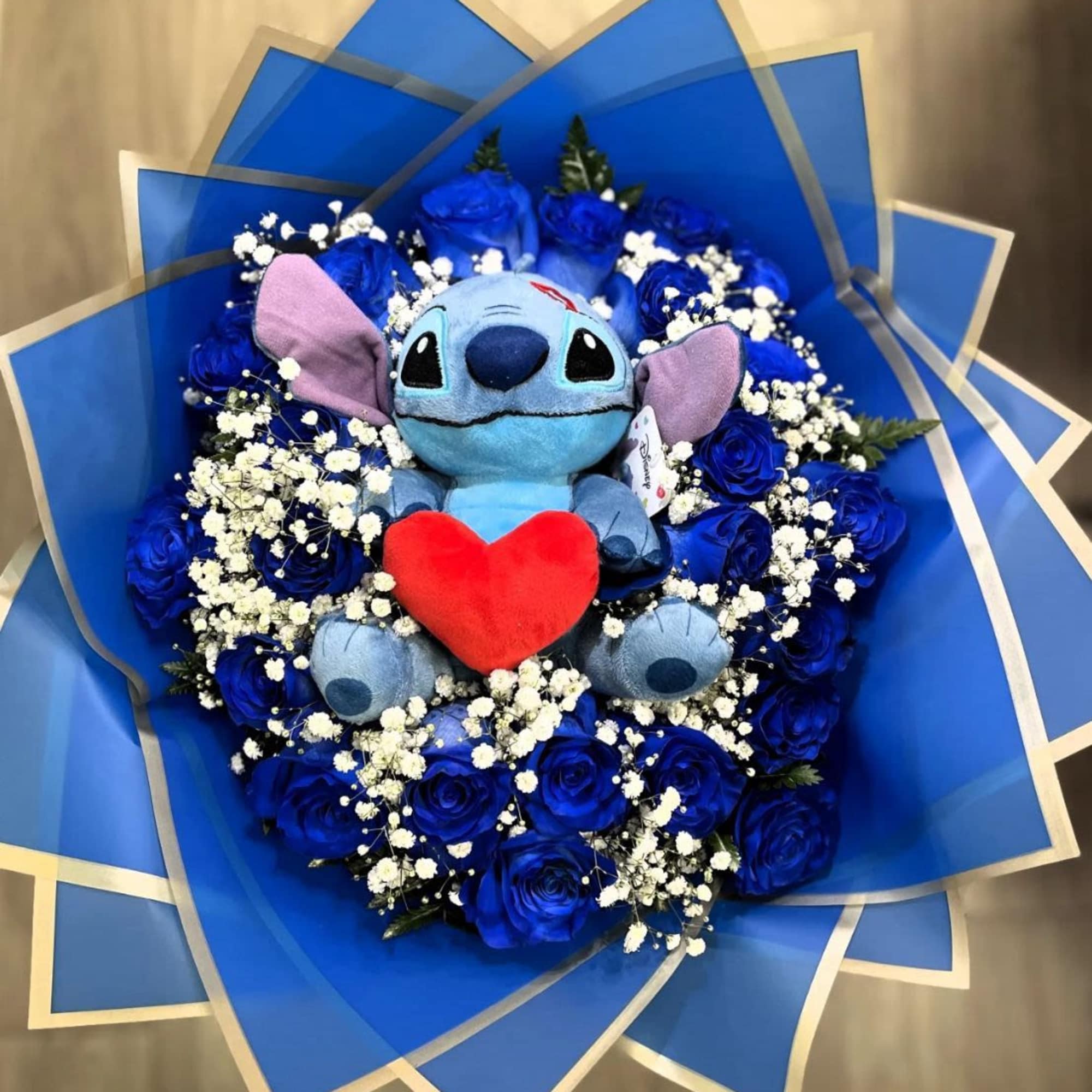 detalle elaborado en rosas azules naturales y stitch en disponibilidad los personajes