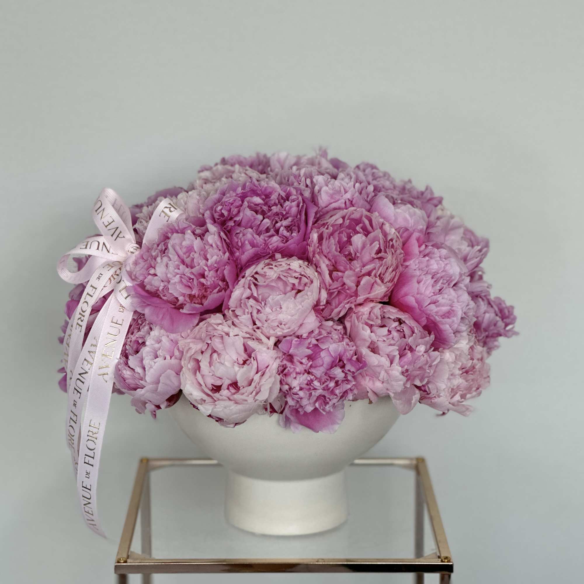 A beautiful, chic vase adorned with soft, lush peonies. A perfect gift
