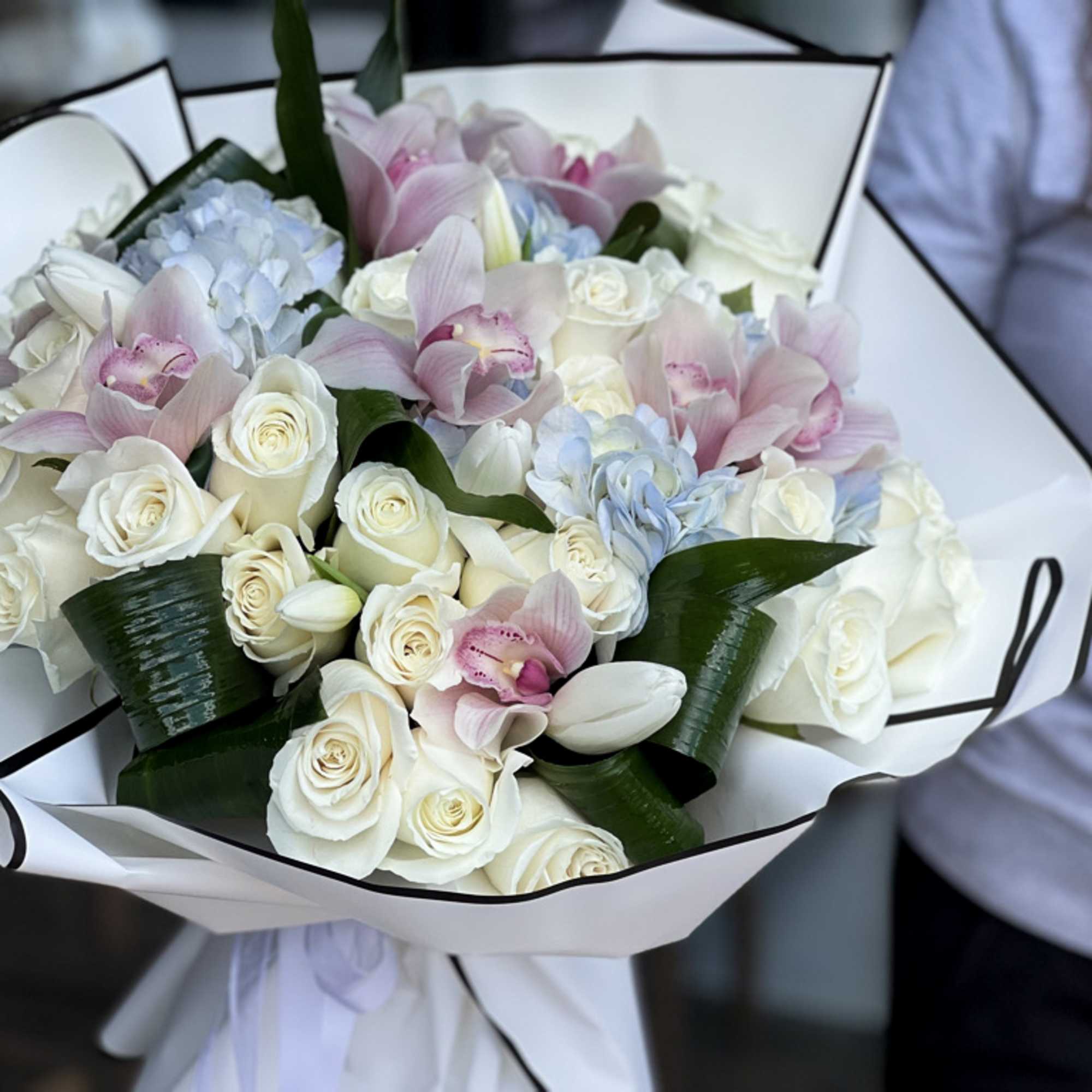 Mixed arrangement with roses, cymbidium orchids and tulips 
Vase not included 