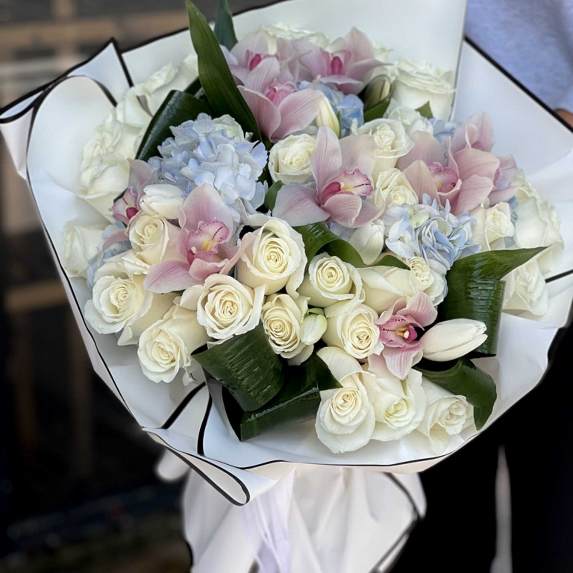 Mixed arrangement with roses, cymbidium orchids and tulips 
Vase not included 