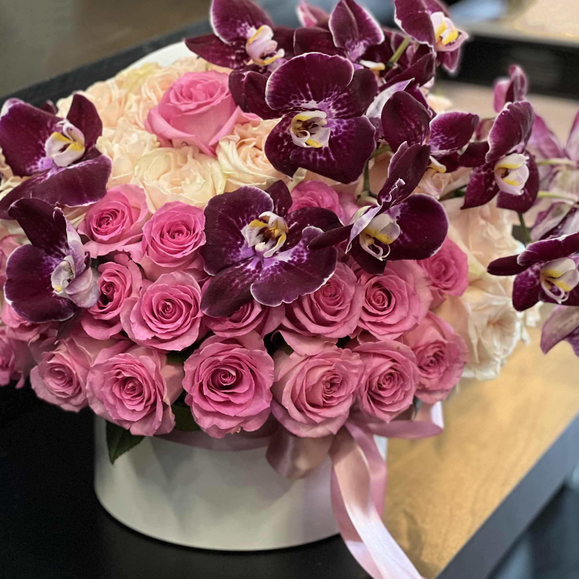 Luxurious arrangement with 75 and above peach and pink roses with phalaenopsis