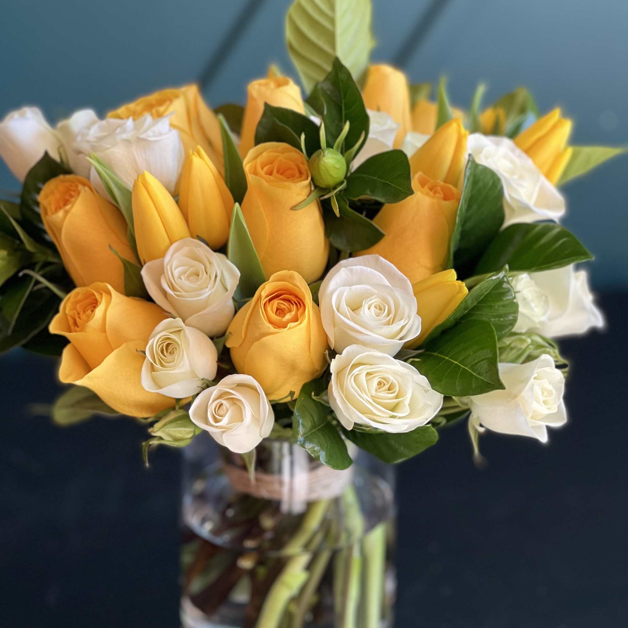 Bright Arrangement in a vase with yellow and white roses, tulips and