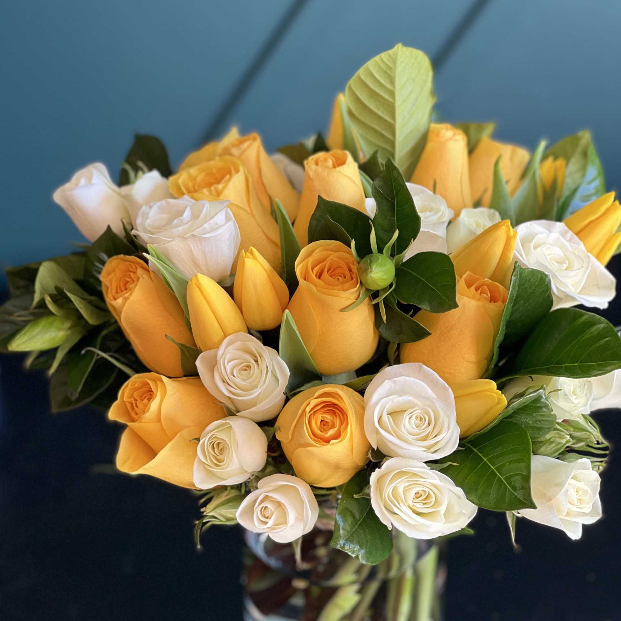 Bright Arrangement in a vase with yellow and white roses, tulips and