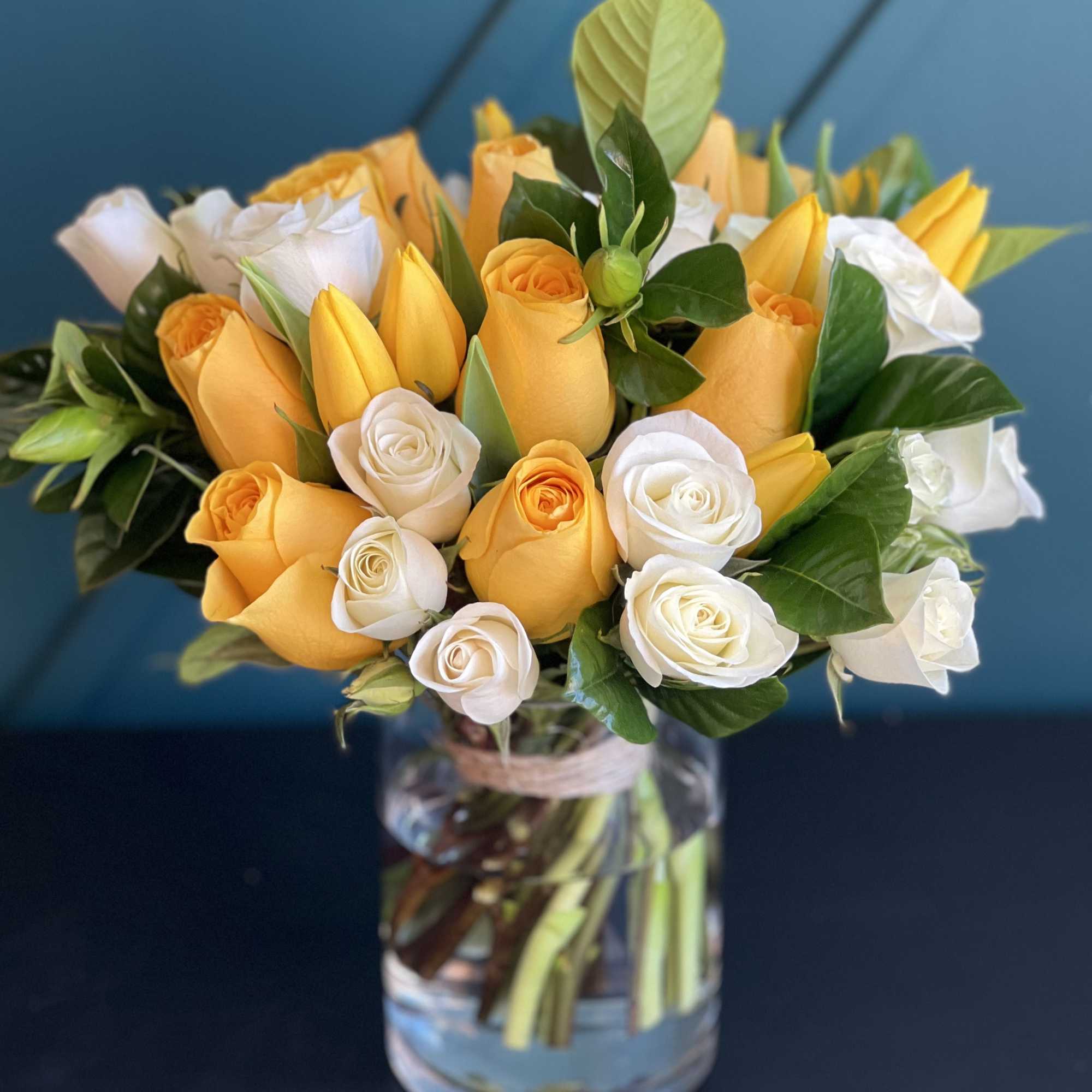 Bright Arrangement in a vase with yellow and white roses, tulips and