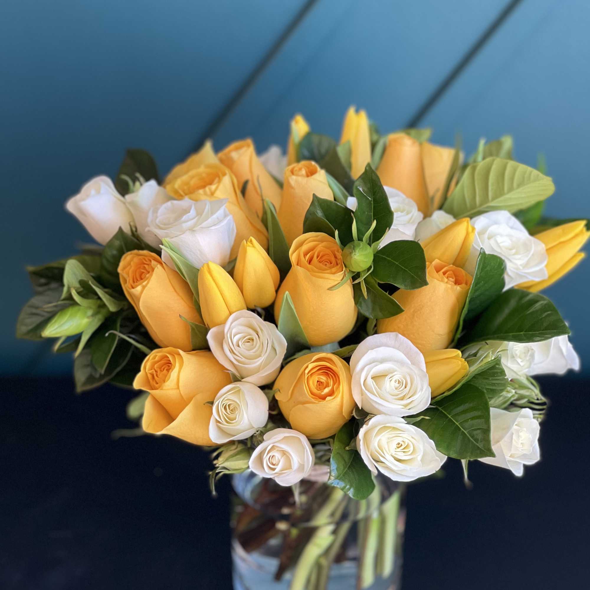 Bright Arrangement in a vase with yellow and white roses, tulips and