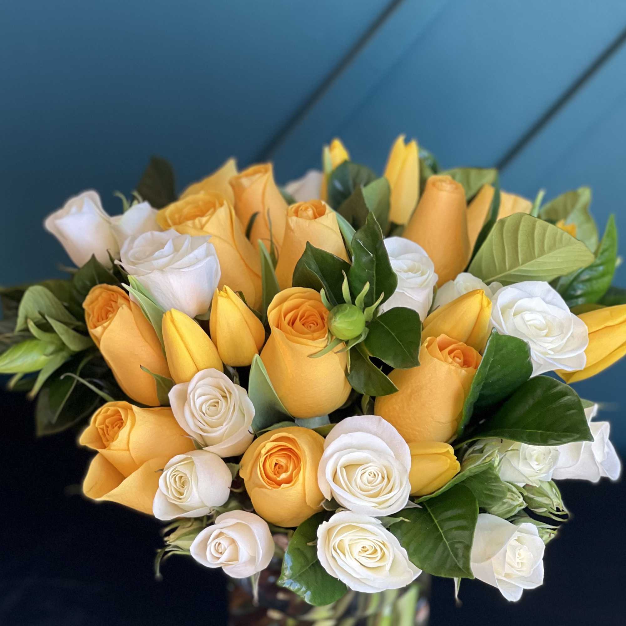 Bright Arrangement in a vase with yellow and white roses, tulips and