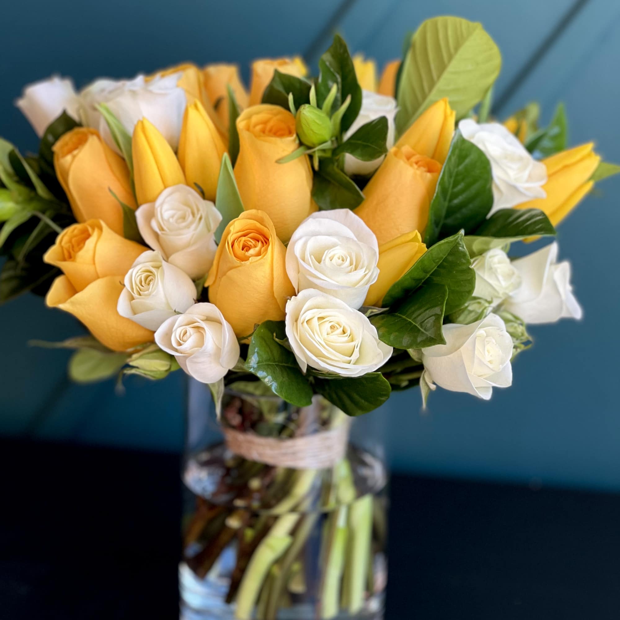 Bright Arrangement in a vase with yellow and white roses, tulips and