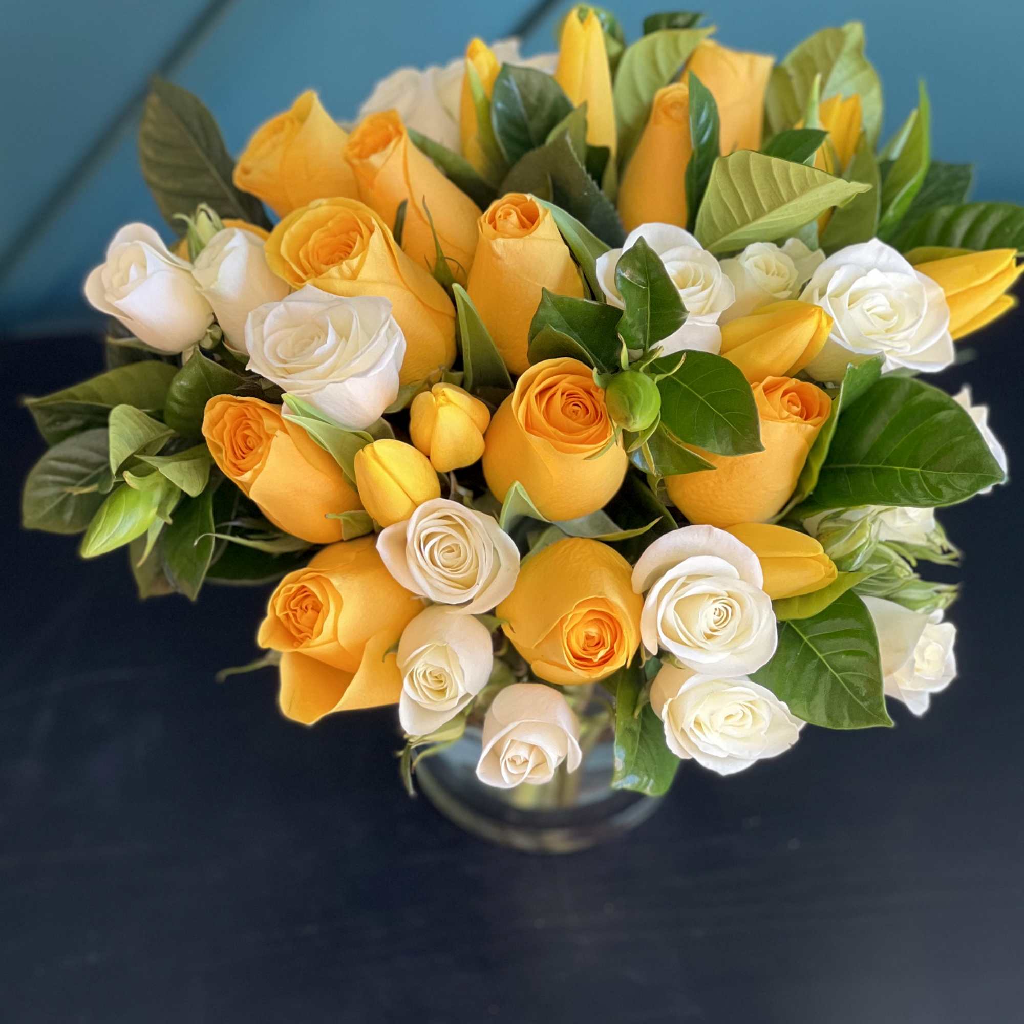 Bright Arrangement in a vase with yellow and white roses, tulips and