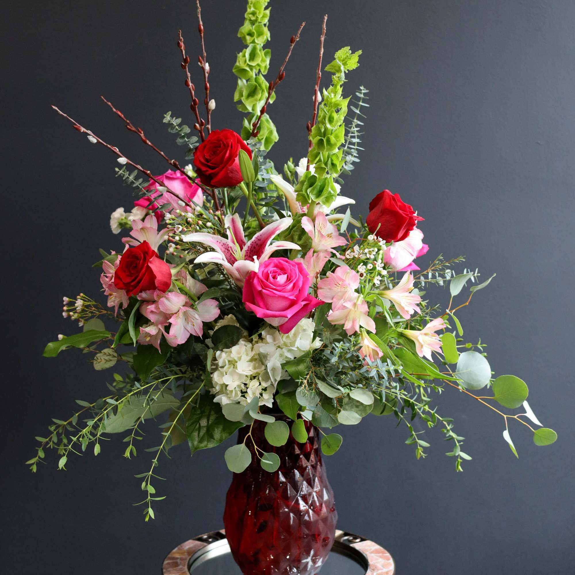 A lush airy arrangement filled with Roses, Lilies, Alstroemeria, Bells of Ireland A lush airy arrangement filled with Roses, Lilies, Alstroemeria, Bells of Ireland