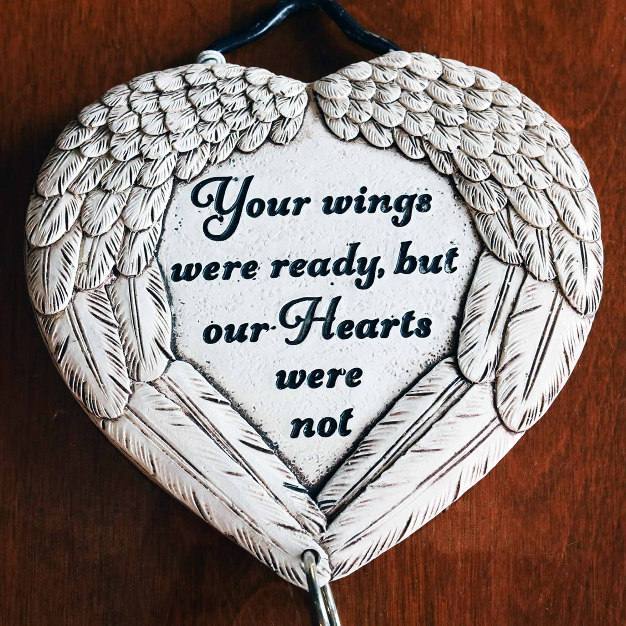 A gorgeous sympathy arrangement with a small hanging wind chime keepsake with