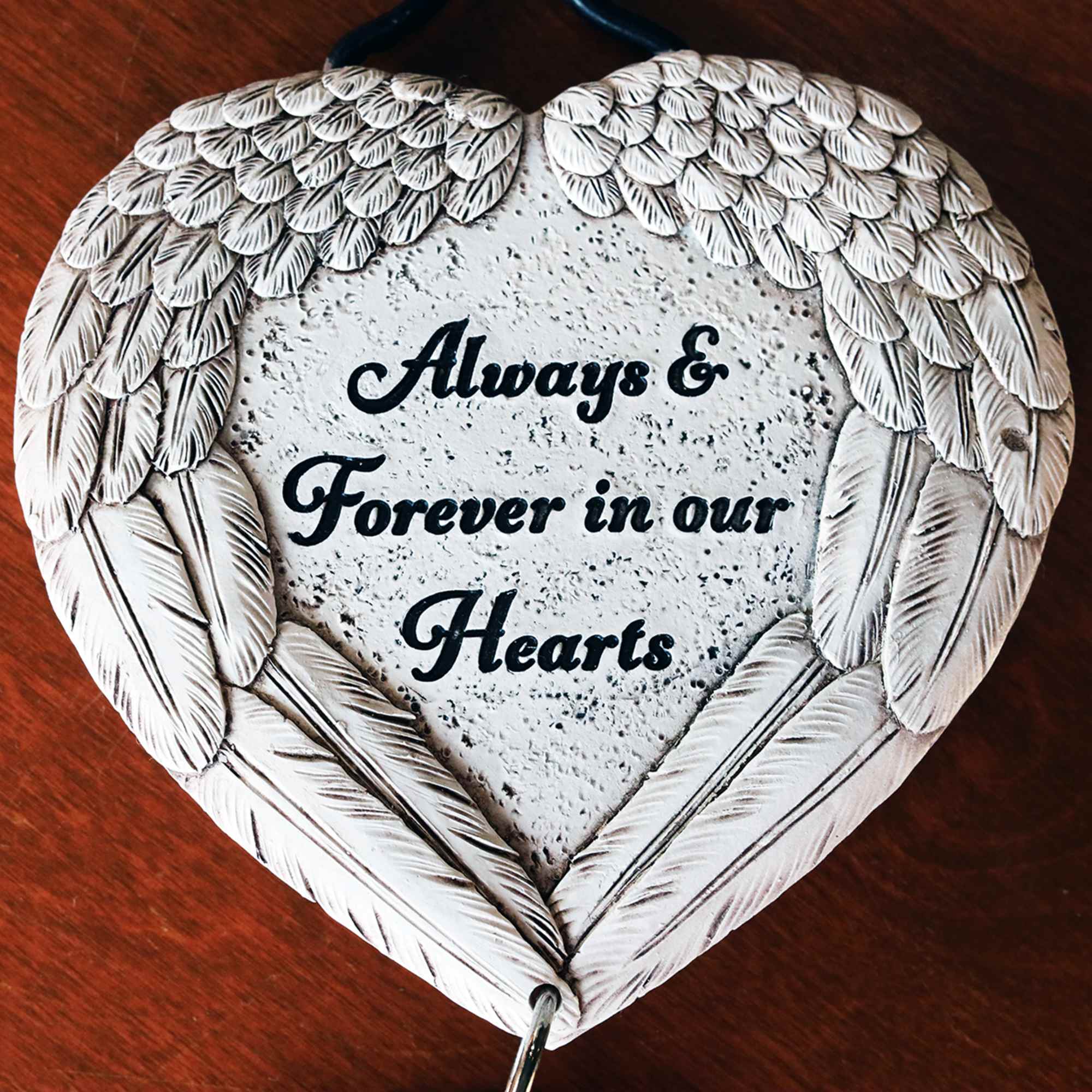 A gorgeous sympathy arrangement with a small hanging wind chime keepsake with