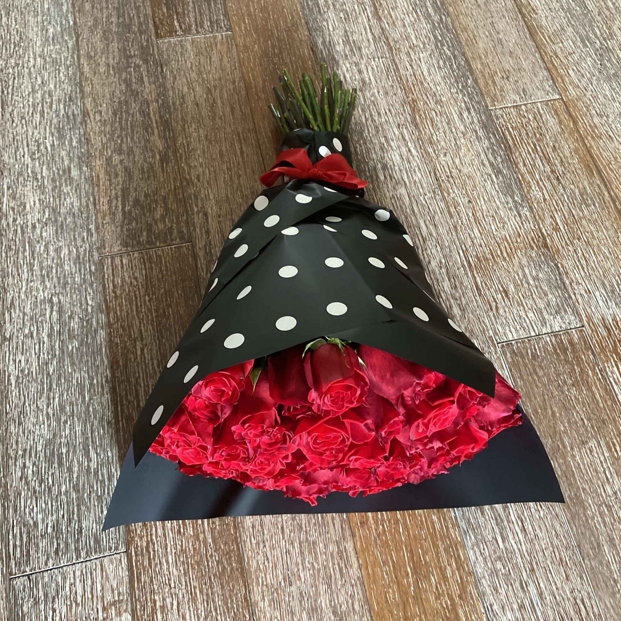 50 Red Roses Wrapped with Black Paper and White Balls.