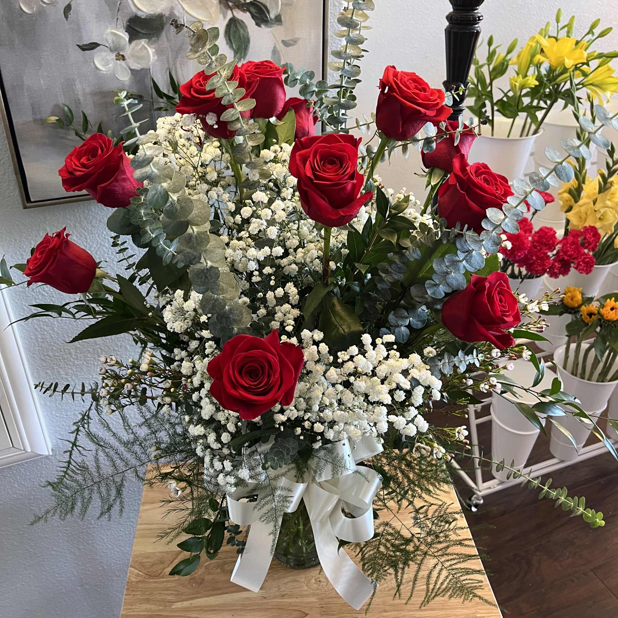 Dozen roses arranged with filler and greens/docena de rosas dispuestas en un