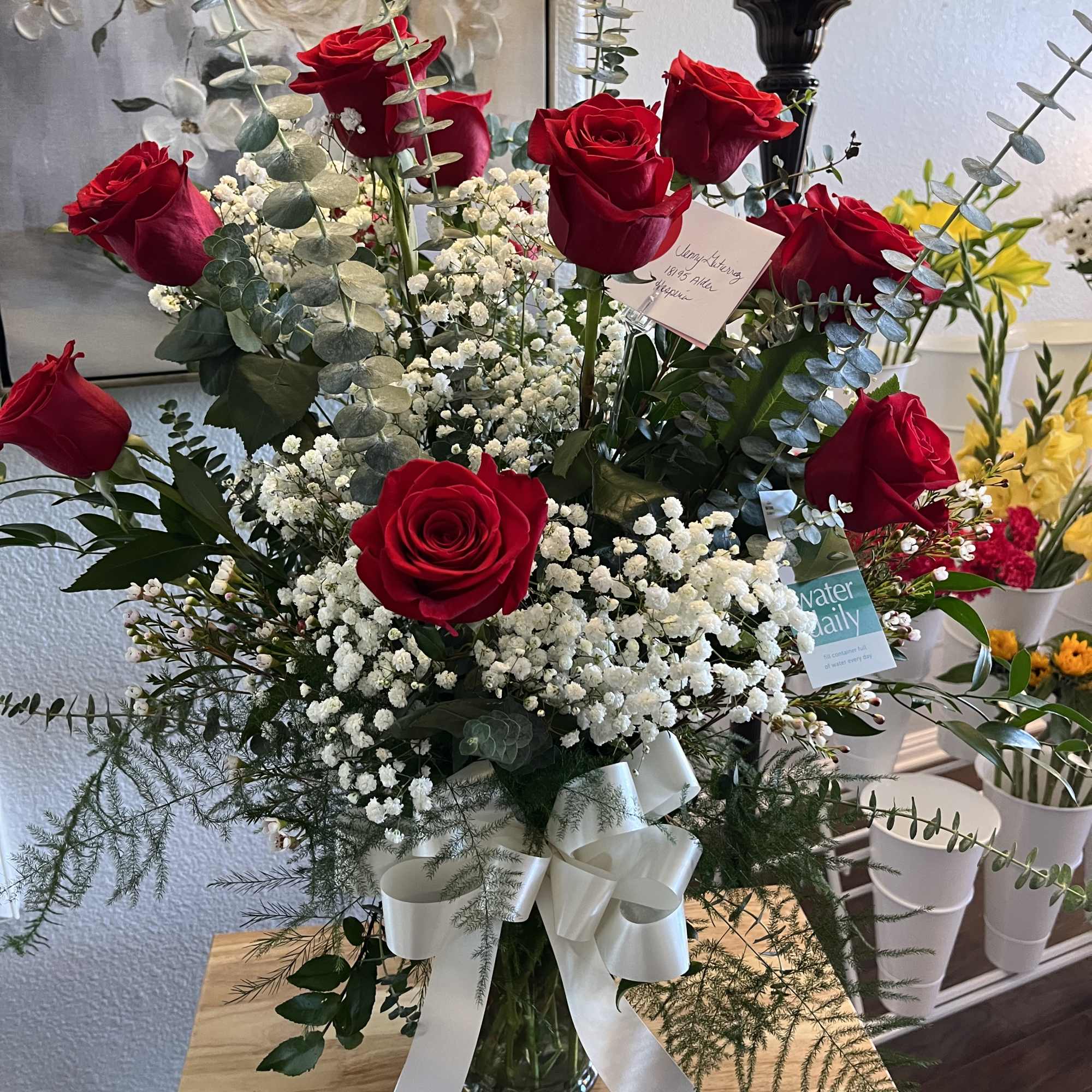 Dozen roses arranged with filler and greens/docena de rosas dispuestas en un