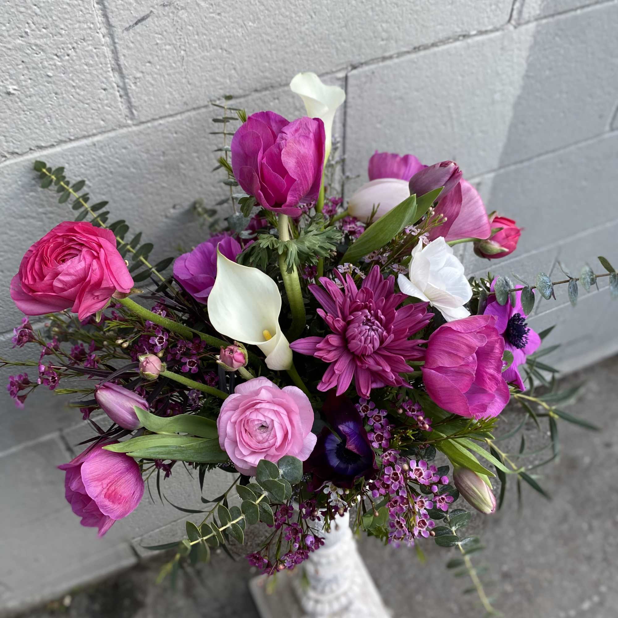 A mix assortment of magenta flowers such as anemones, calla lilies, ranunculus