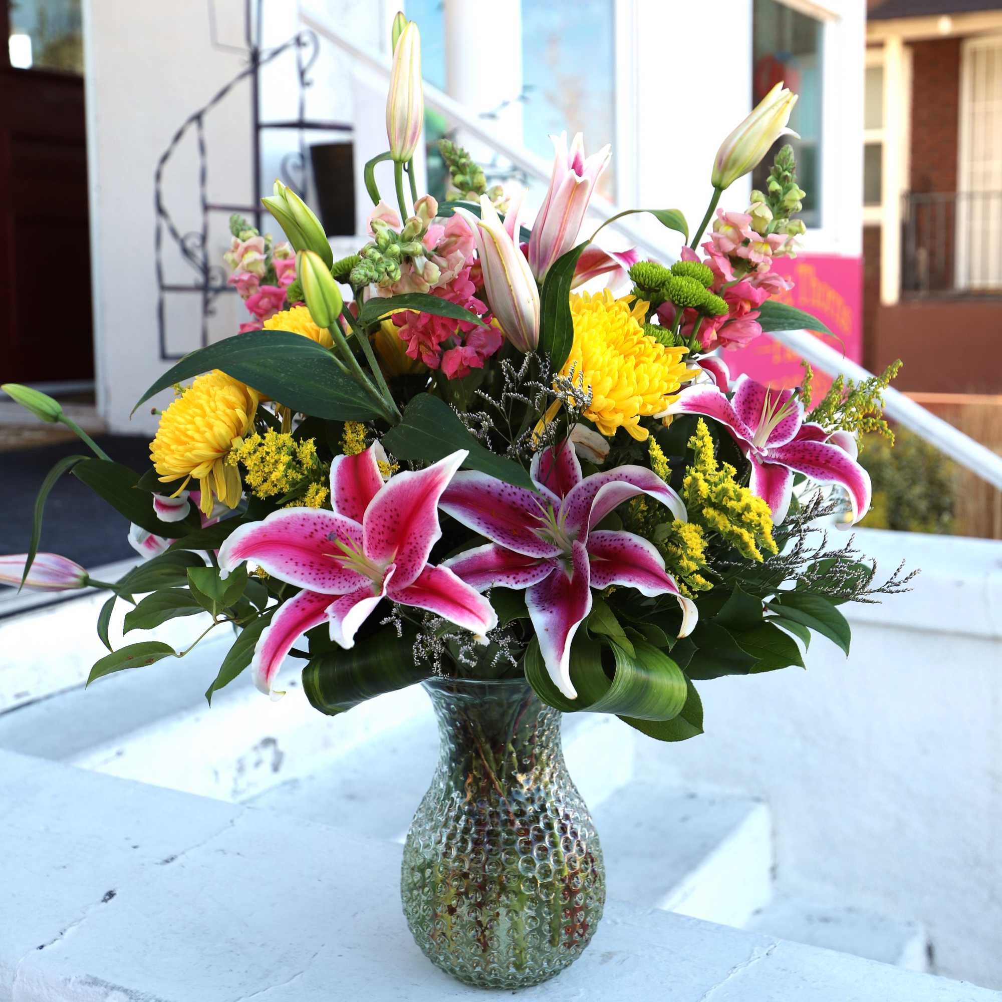 A stunning floral arrangement made in a fun textured vase with brightly