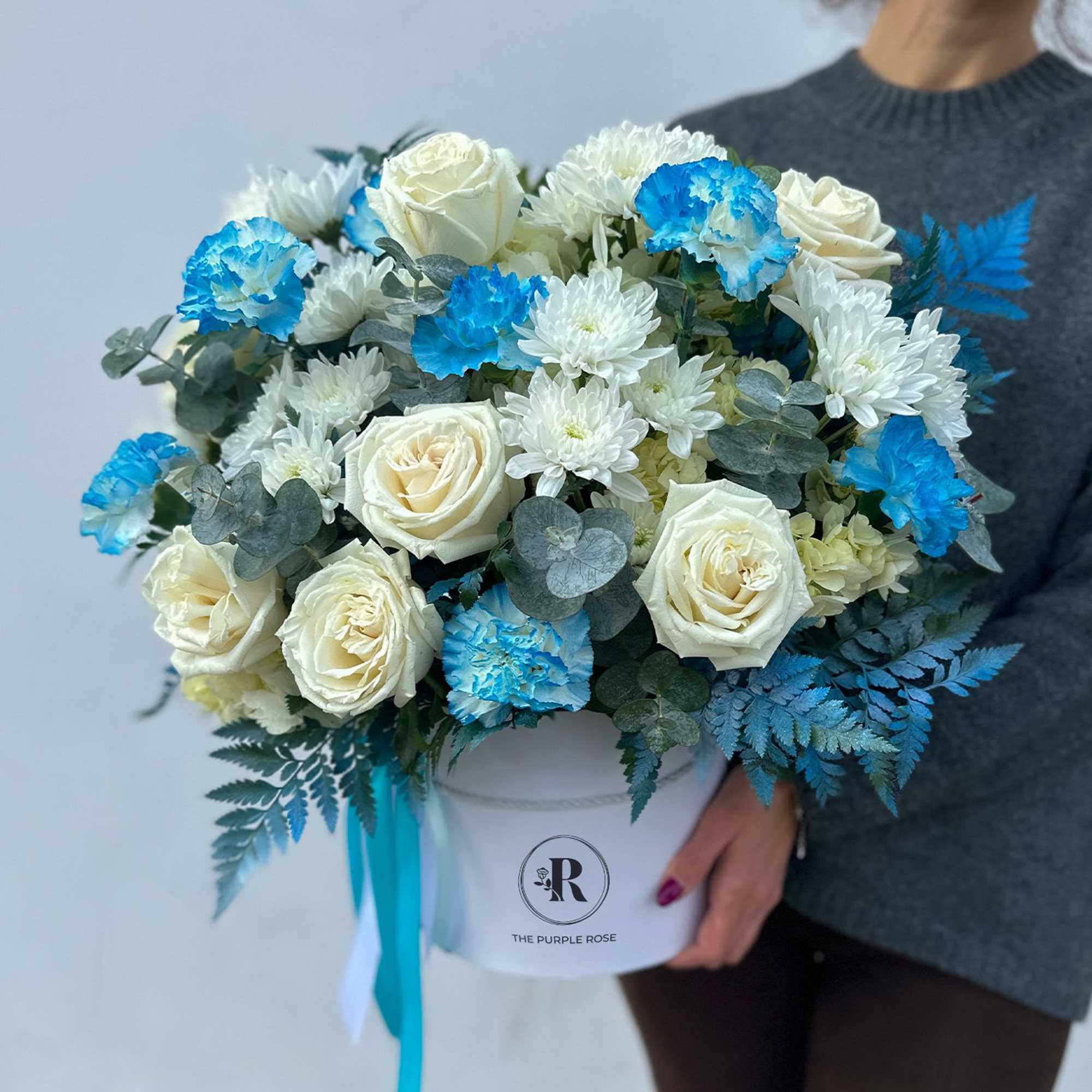 This flower arrangement features a stunning combination of white roses, white chrysanthemums