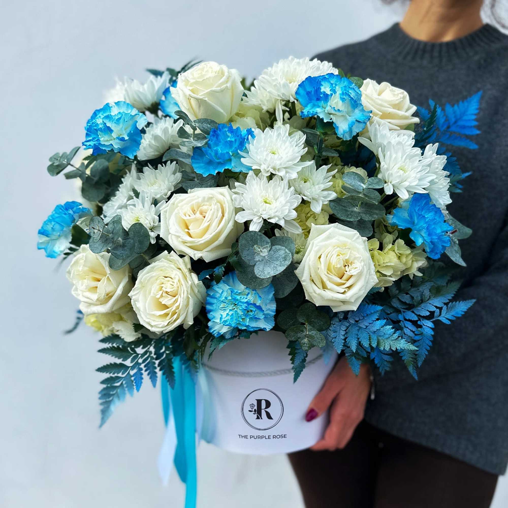 This flower arrangement features a stunning combination of white roses, white chrysanthemums