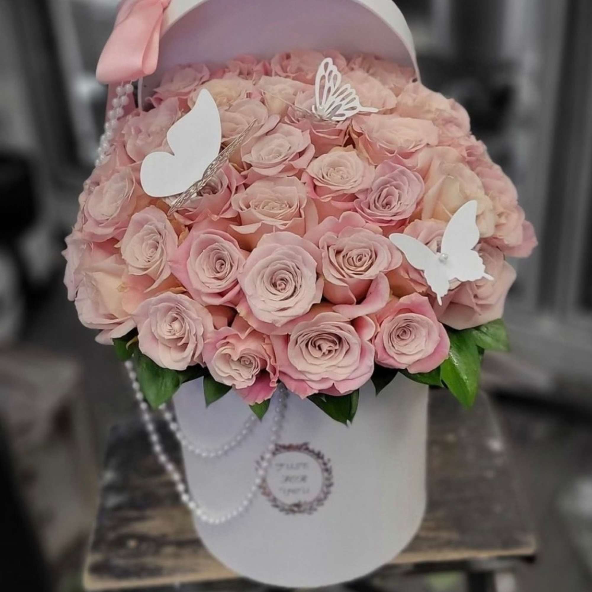 A pink box filled with pink roses. Decorated with pearls and gold A pink box filled with pink roses. Decorated with pearls and gold