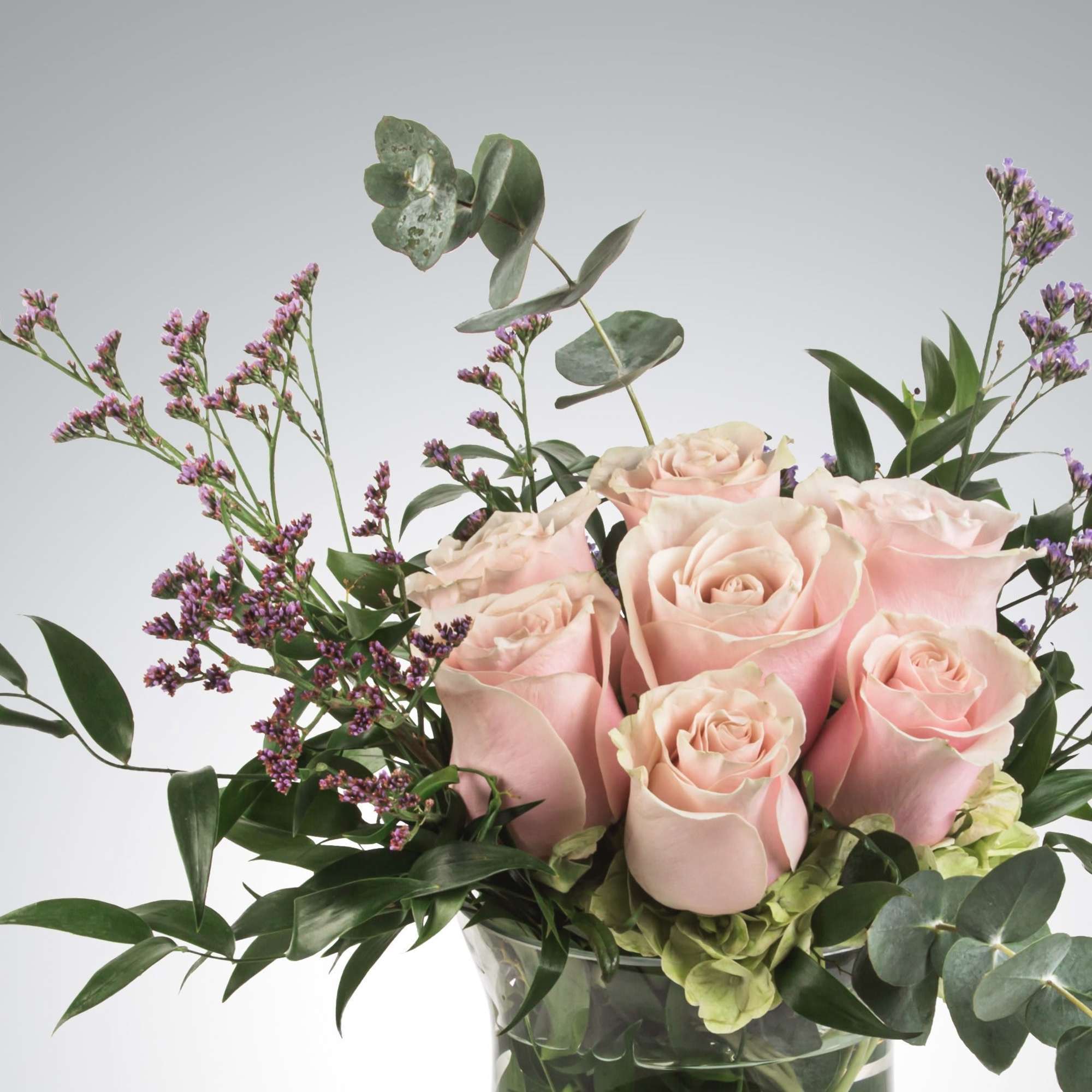 Blush roses with a variety of greenery and eucalyptus come together for