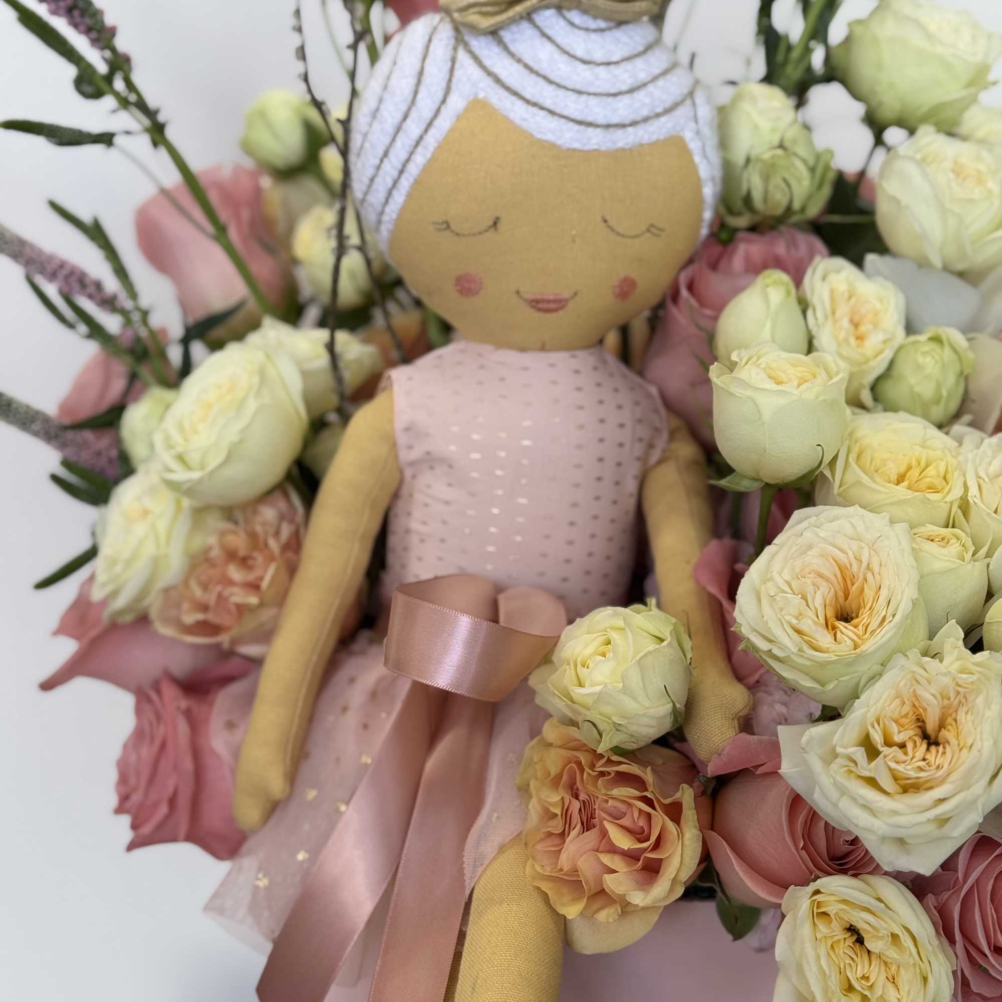 A charming pink floral arrangement featuring roses, orchids, and delicate accent flowers