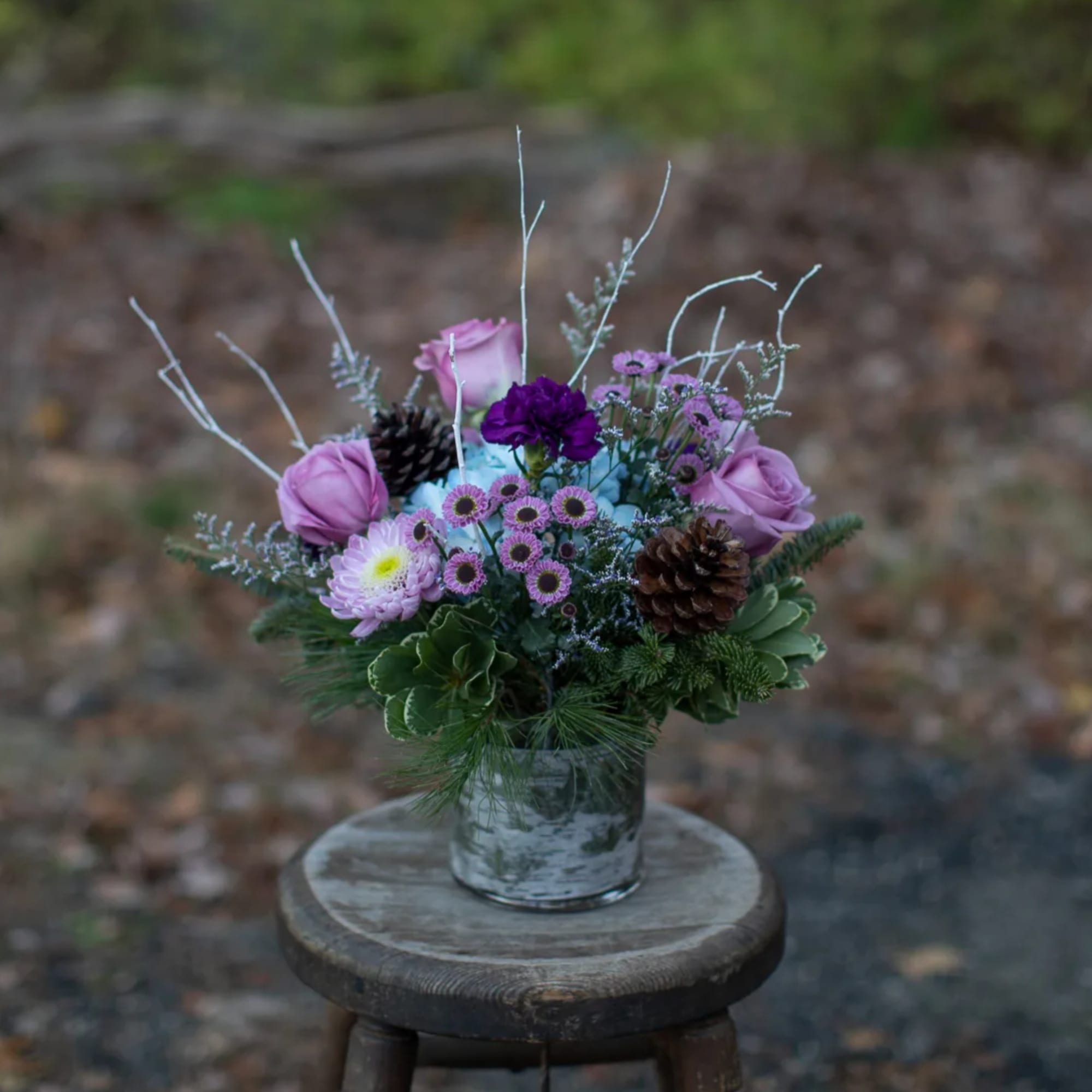 Nested in seasonal foliage are cool indigo and blue toned floral varieties Nested in seasonal foliage are cool indigo and blue toned floral varieties