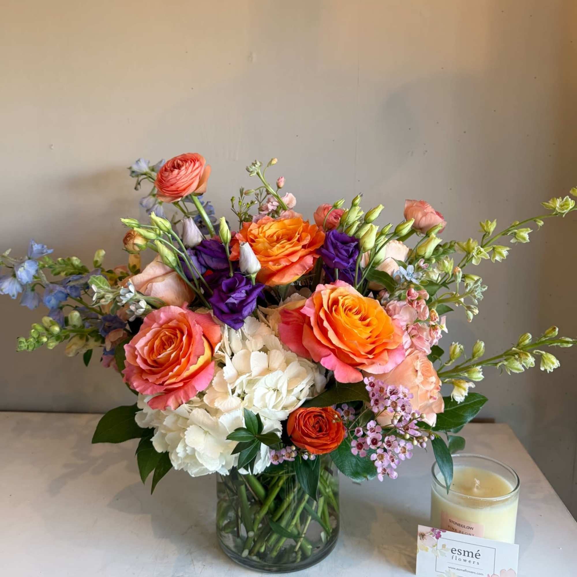 This stunning arrangement combines the fiery zest of orange, pops of purple This stunning arrangement combines the fiery zest of orange, pops of purple