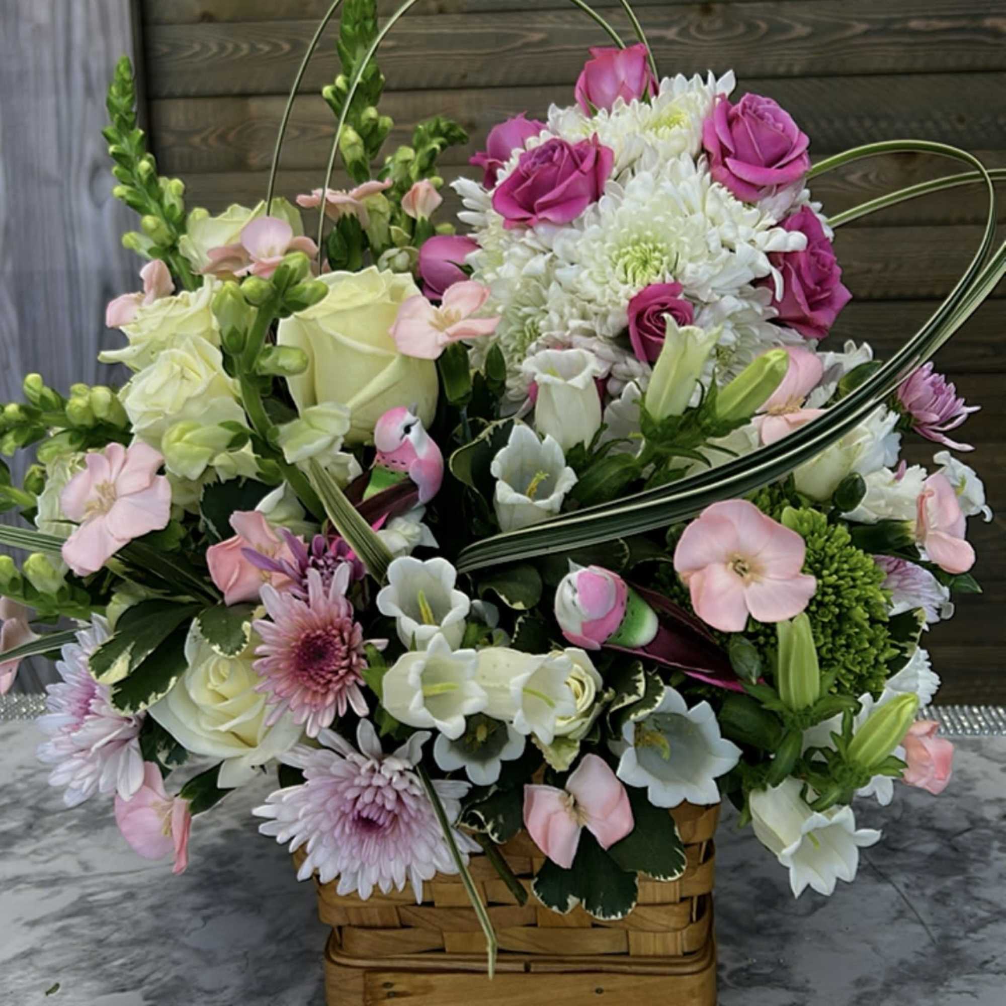 This charming arrangement showcases vibrant spring colors and fragant flowers, making it