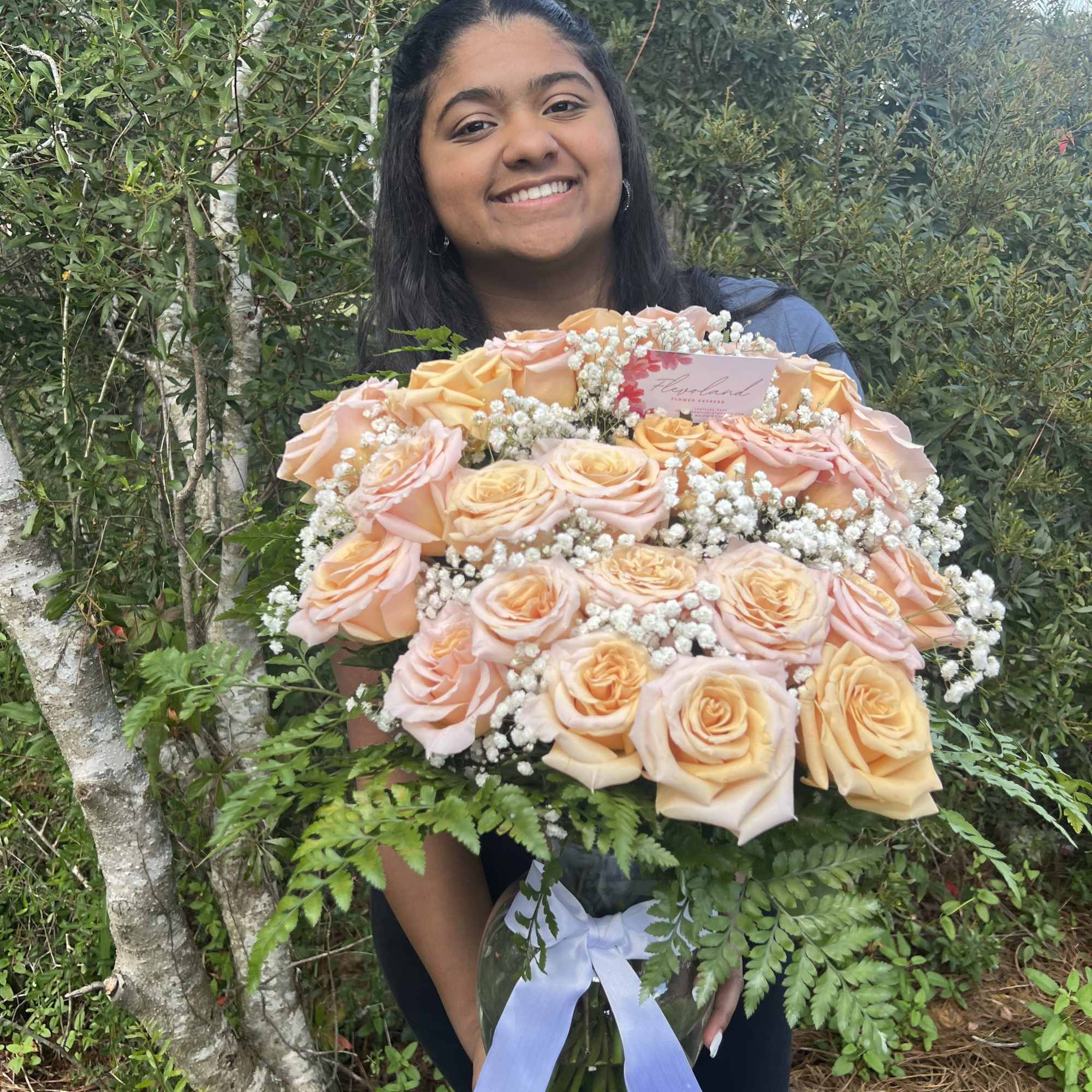 This arrangement of light pink roses, paired with green and white foliage