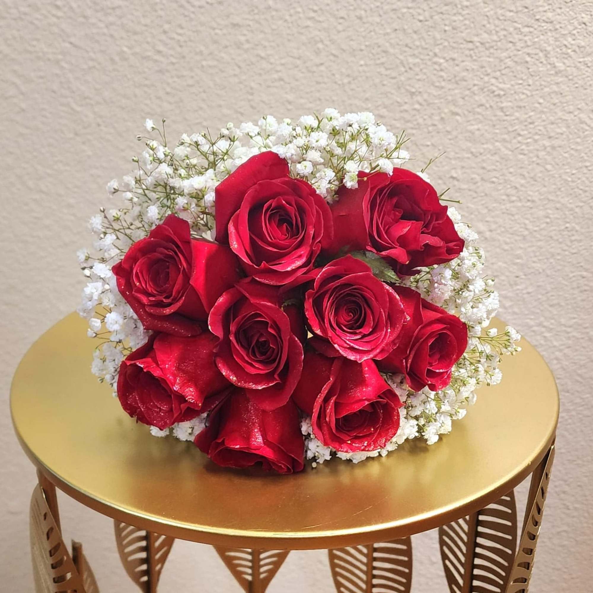 A classic red rose and baby&#039;s breath bouquet hand tied with ribbon.