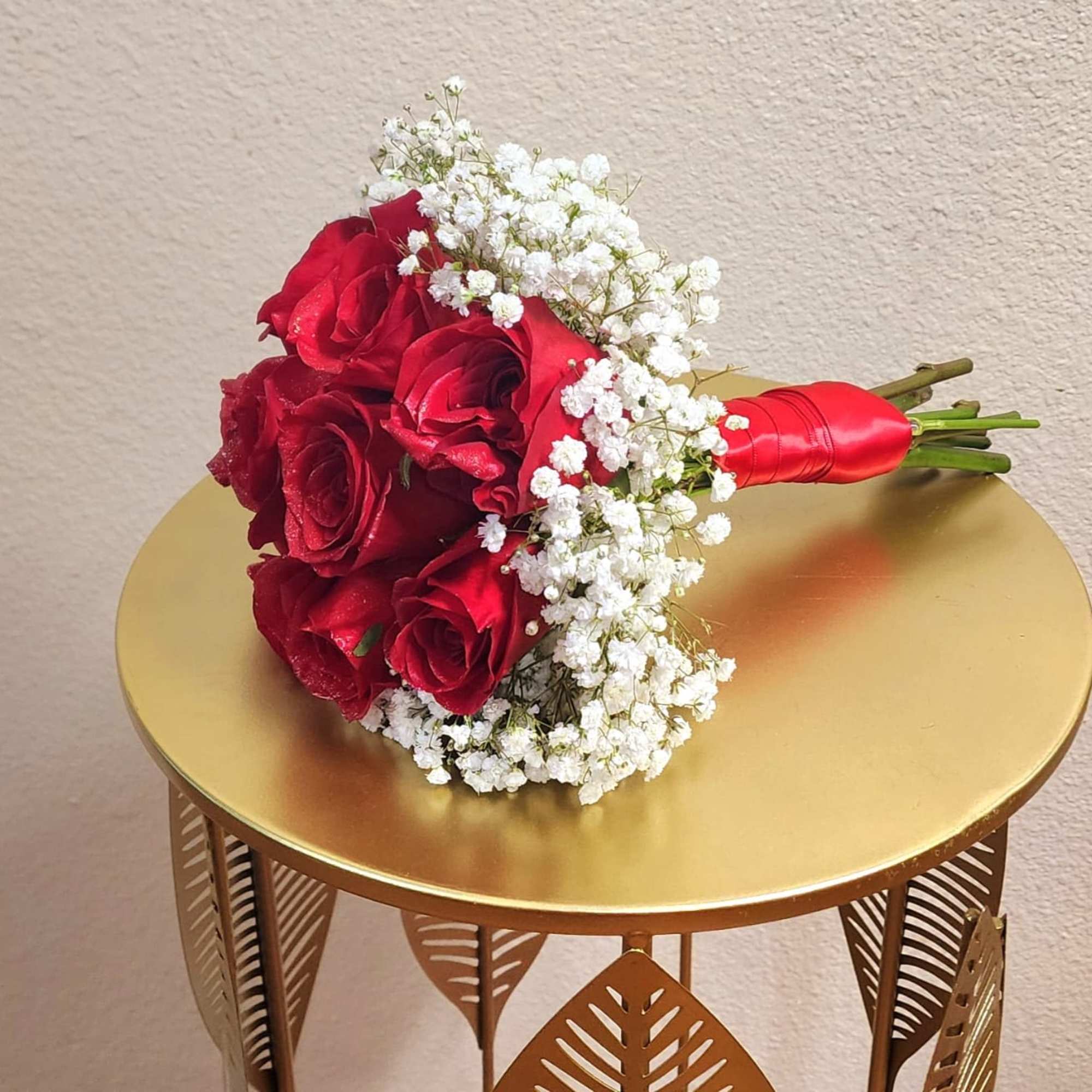 A classic red rose and baby&#039;s breath bouquet hand tied with ribbon.