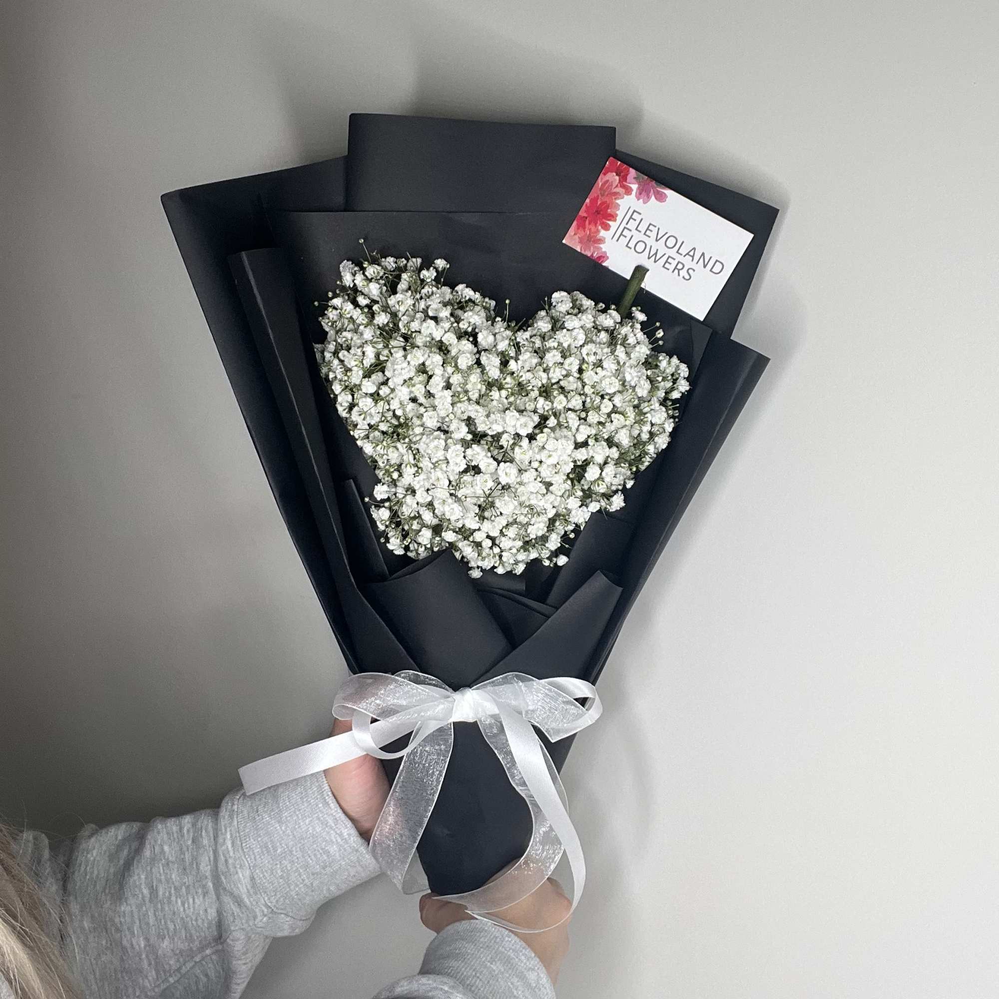 This delicate and romantic arrangement, shaped like a heart, is filled with