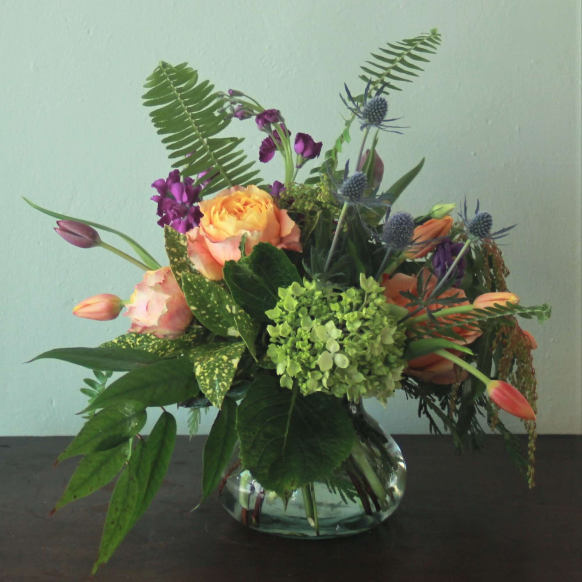 The vibrant colors mixed with striking greenery gathered in a charming posy