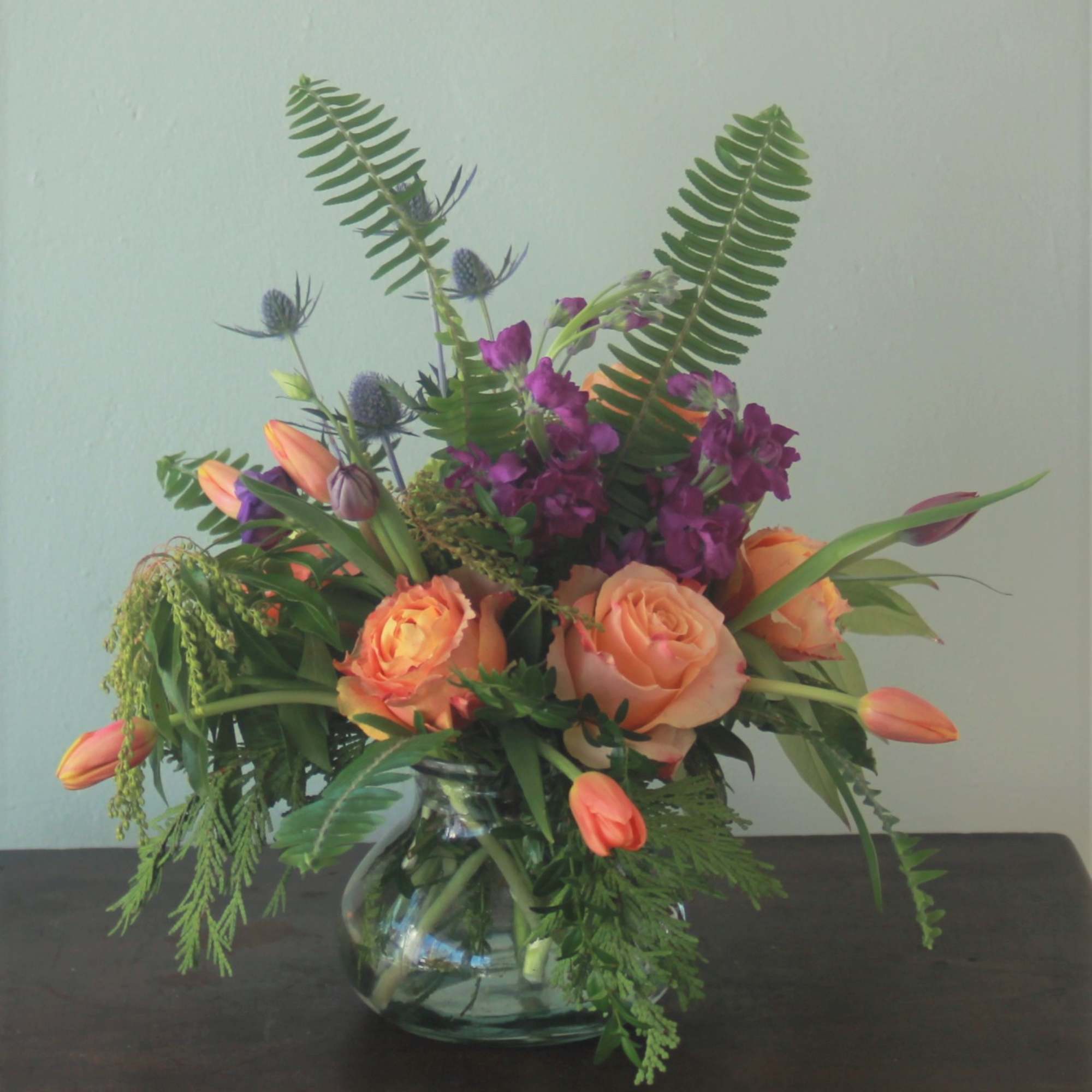 The vibrant colors mixed with striking greenery gathered in a charming posy