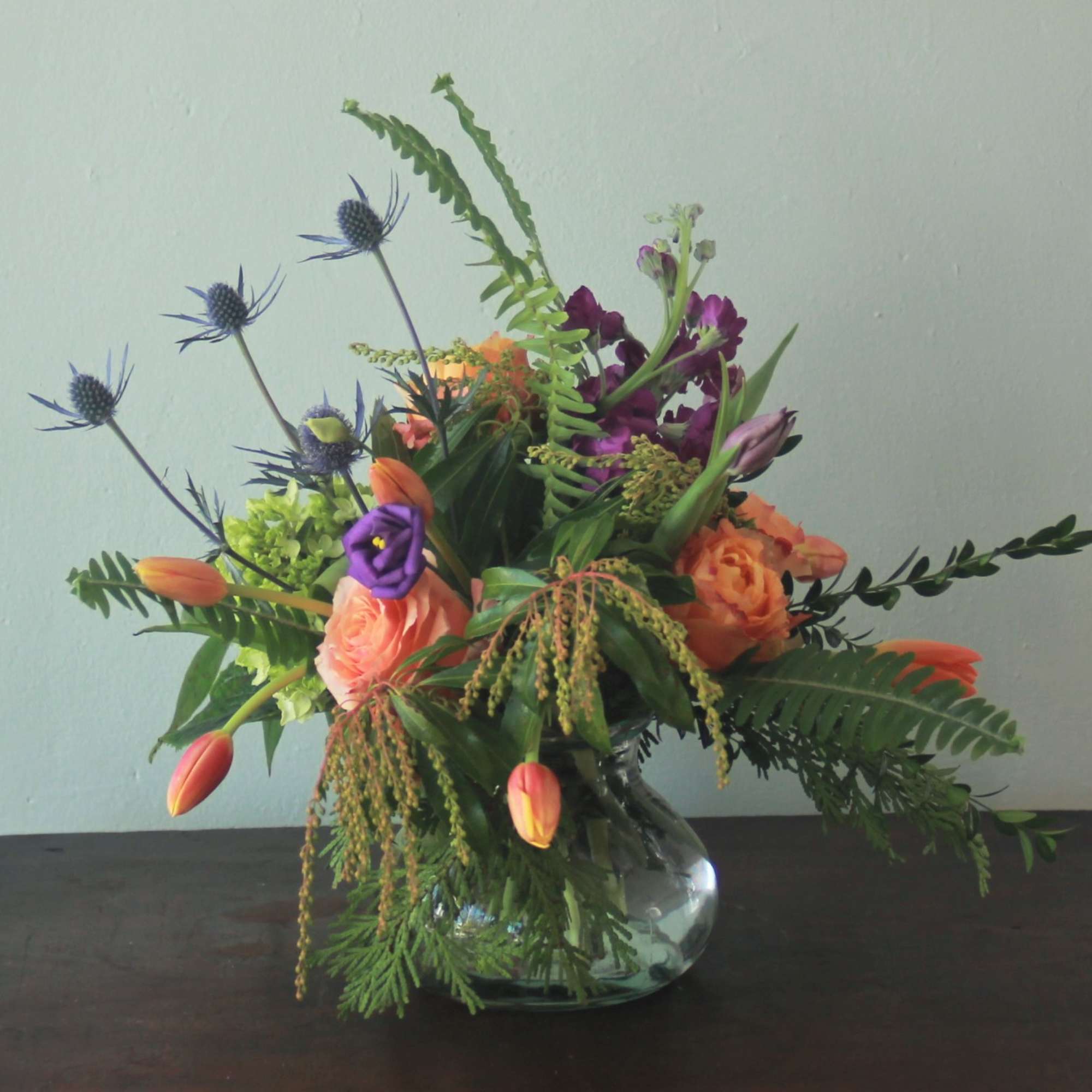 The vibrant colors mixed with striking greenery gathered in a charming posy