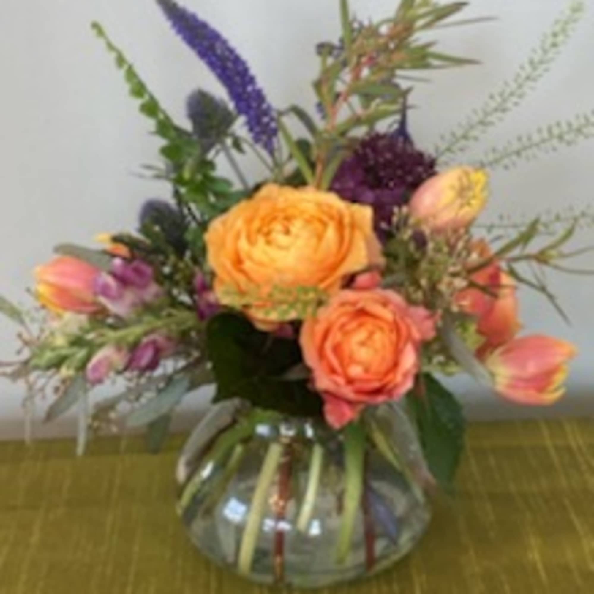 The vibrant colors mixed with striking greenery gathered in a charming posy