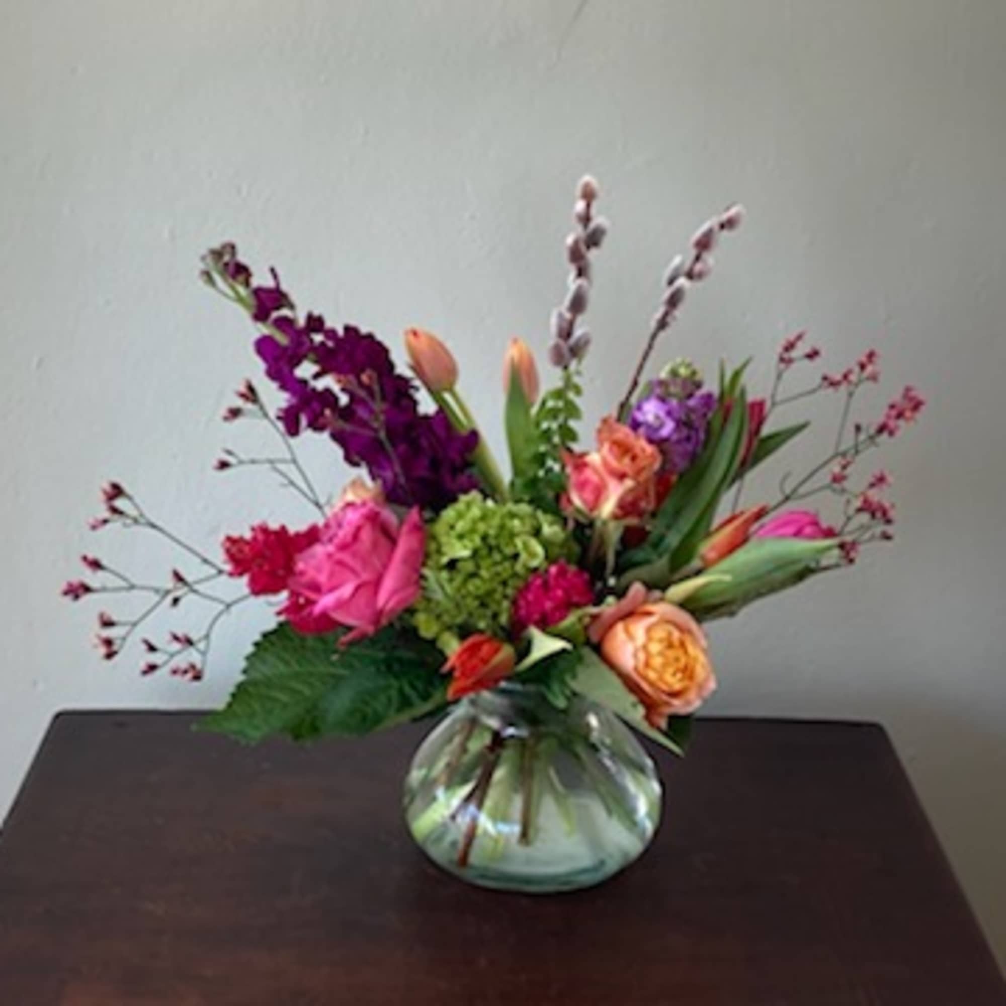 The vibrant colors mixed with striking greenery gathered in a charming posy