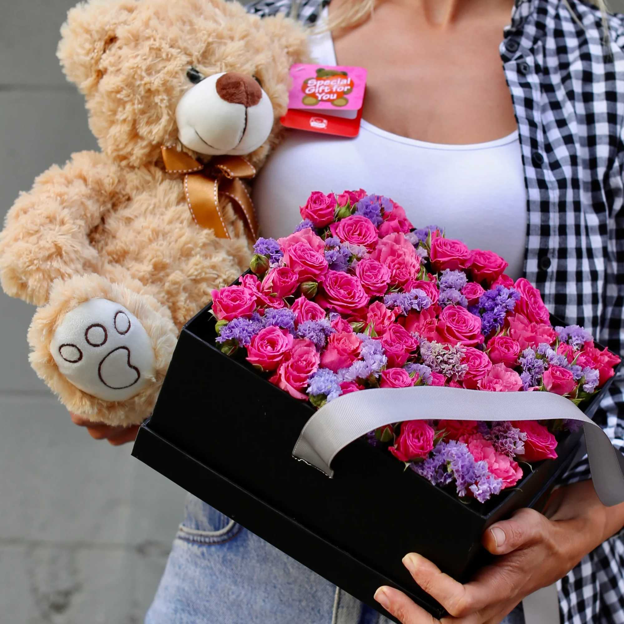 This gift set includes a soft teddy bear and a vibrant arrangement