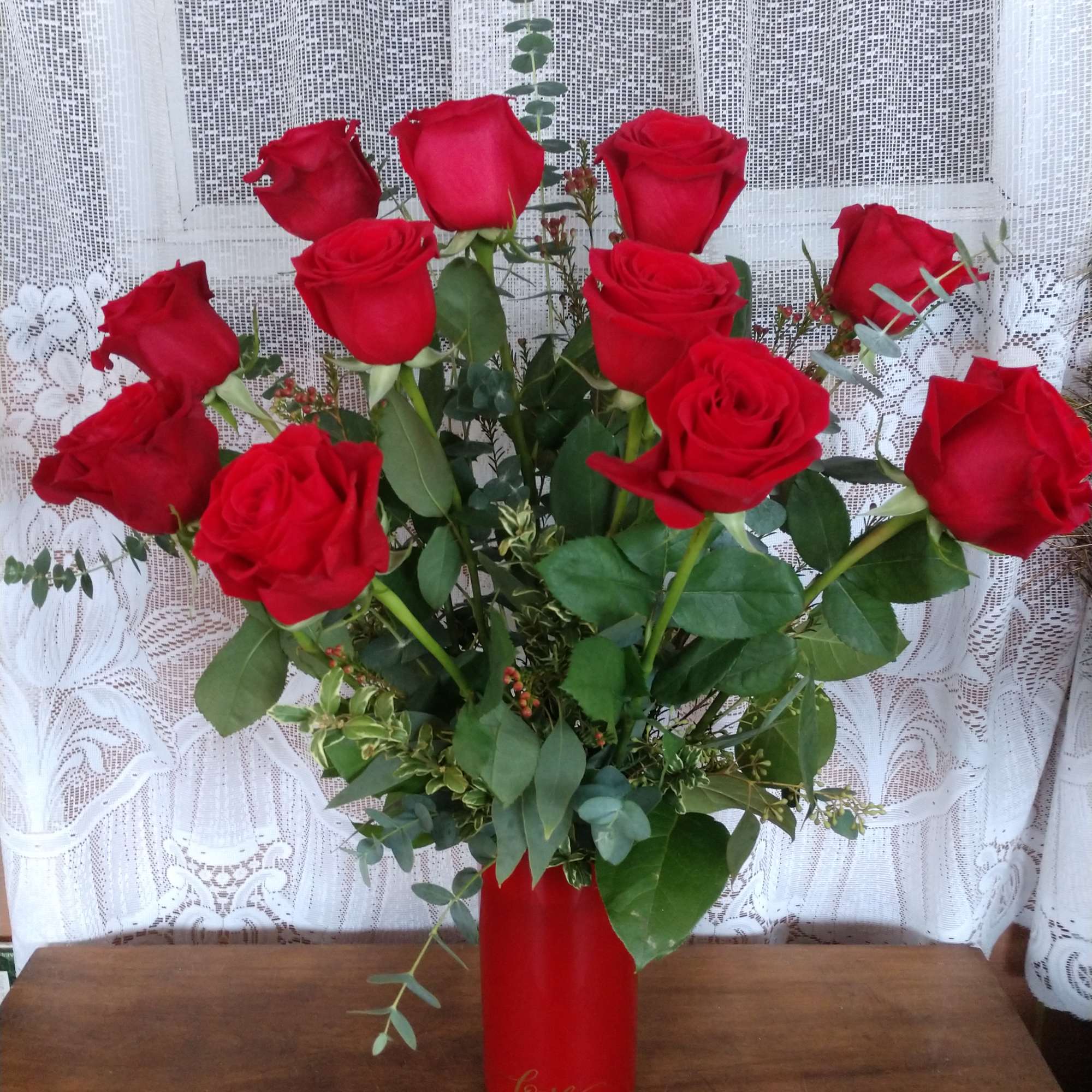Perfectly romantic, these rich red roses arranged in a red glass cylinder