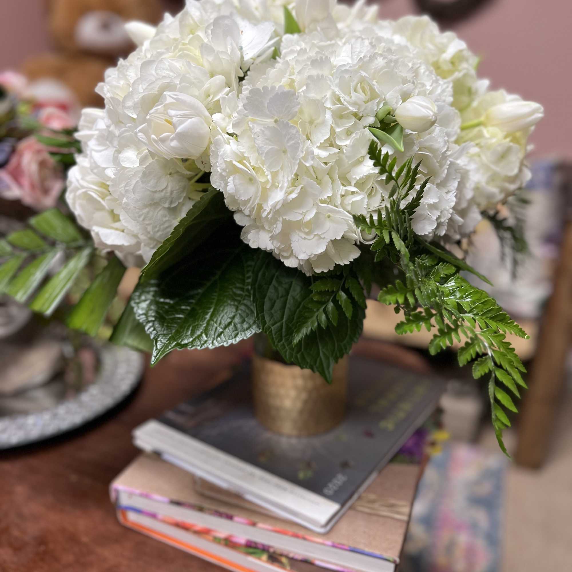 Elegant arrangement of White Hydrangeas and White Lillies with Mixed Greens placed