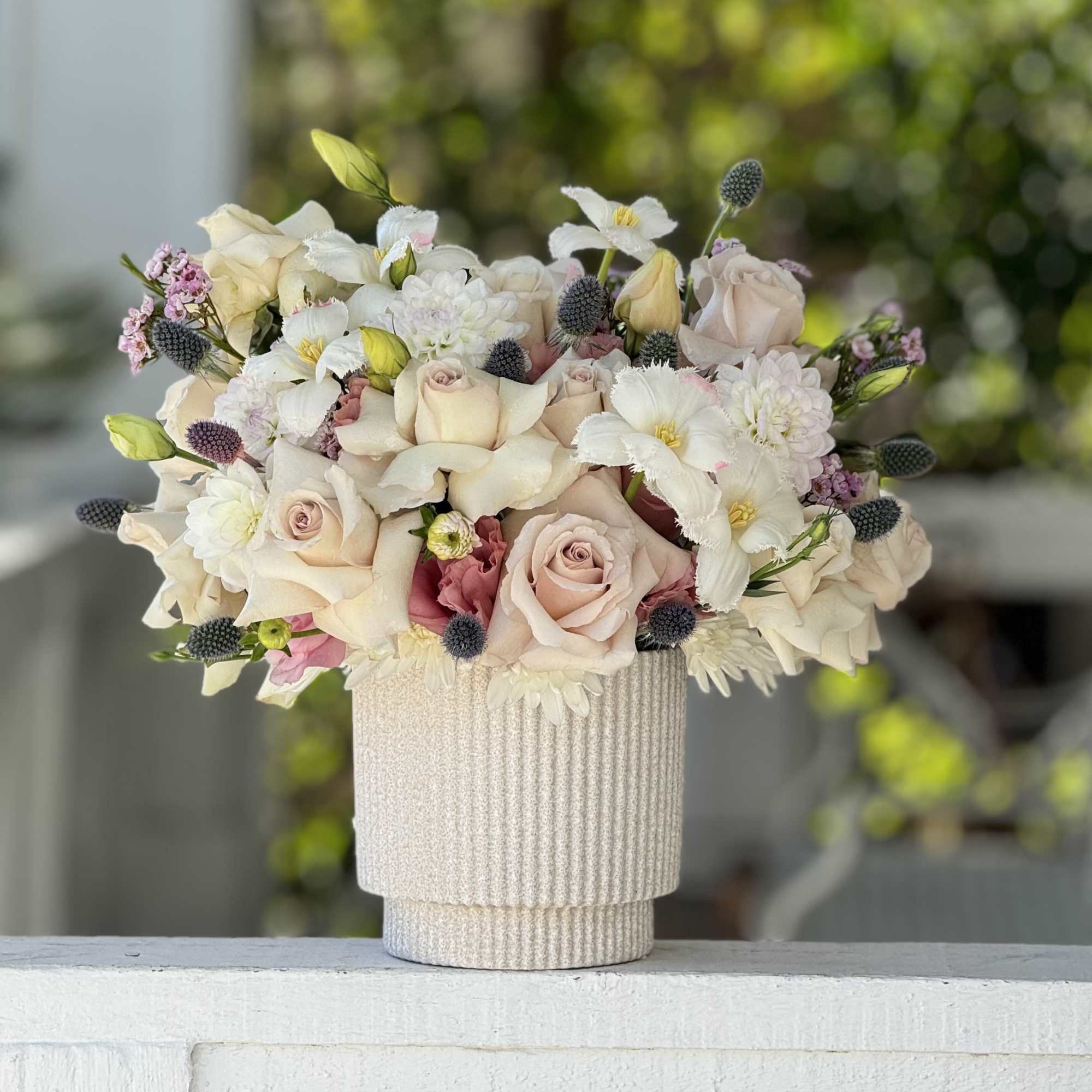 A soft and elegant arrangement of quick sand roses, delicate white tulips
