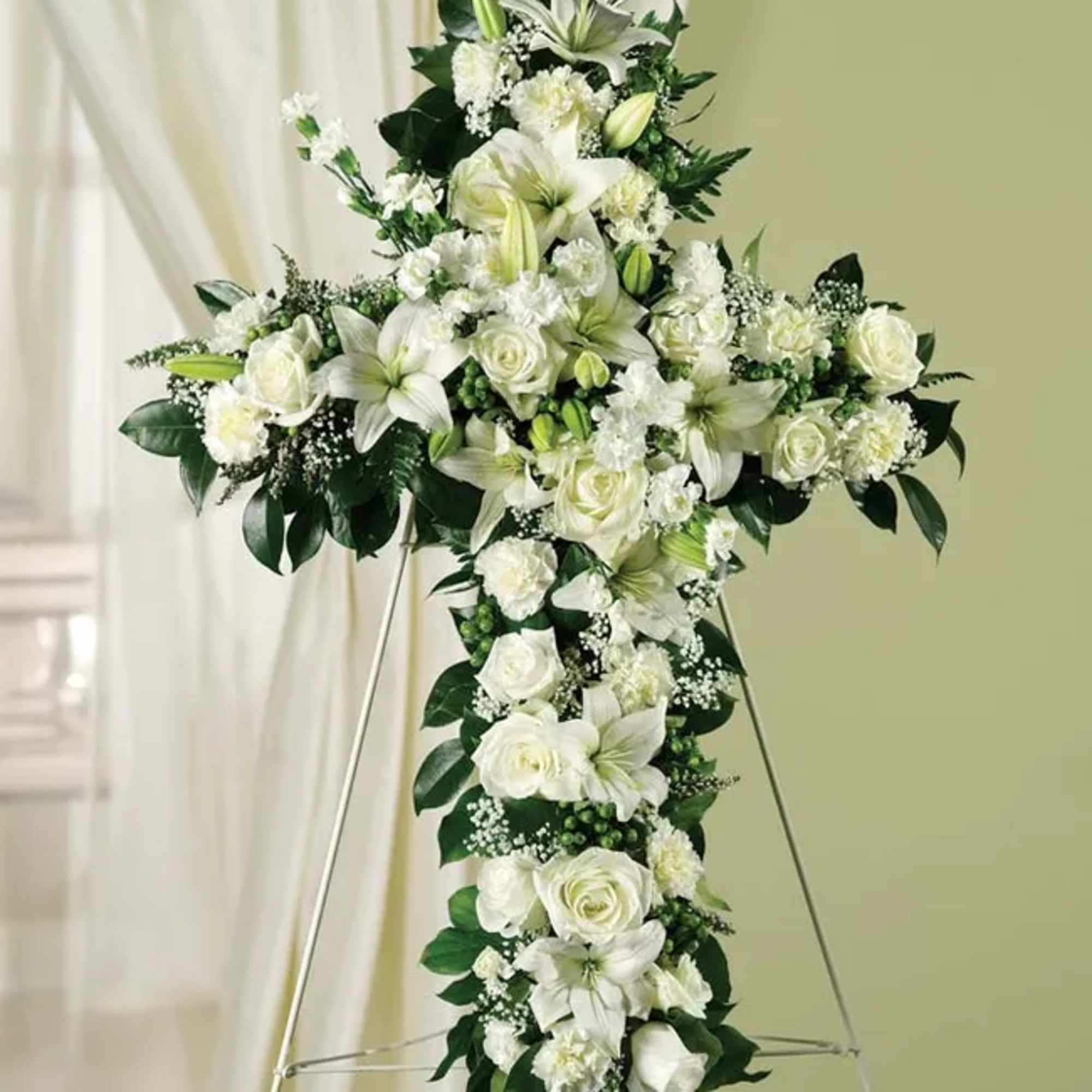 An all white tribute, this white cross funeral spray is pure and