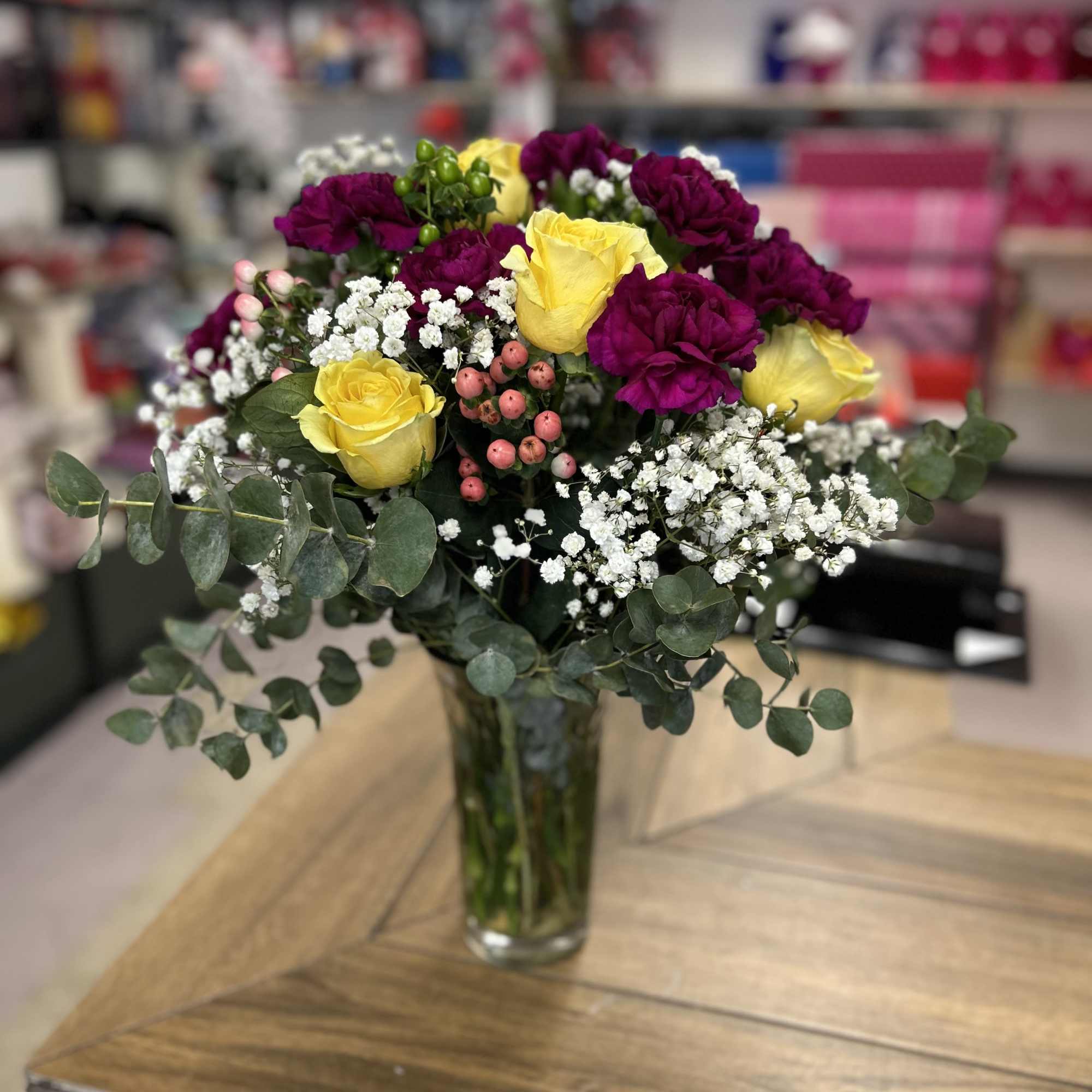 Assorted bouquet in glass base (carnations, roses, roses, and green leaves )