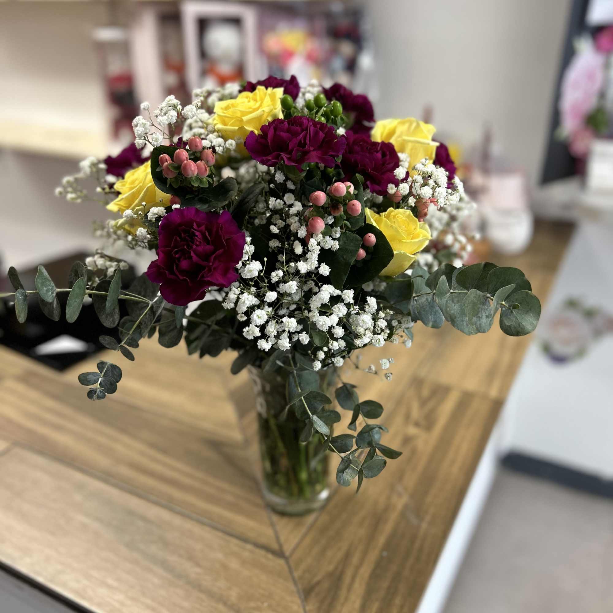 Assorted bouquet in glass base (carnations, roses, roses, and green leaves )