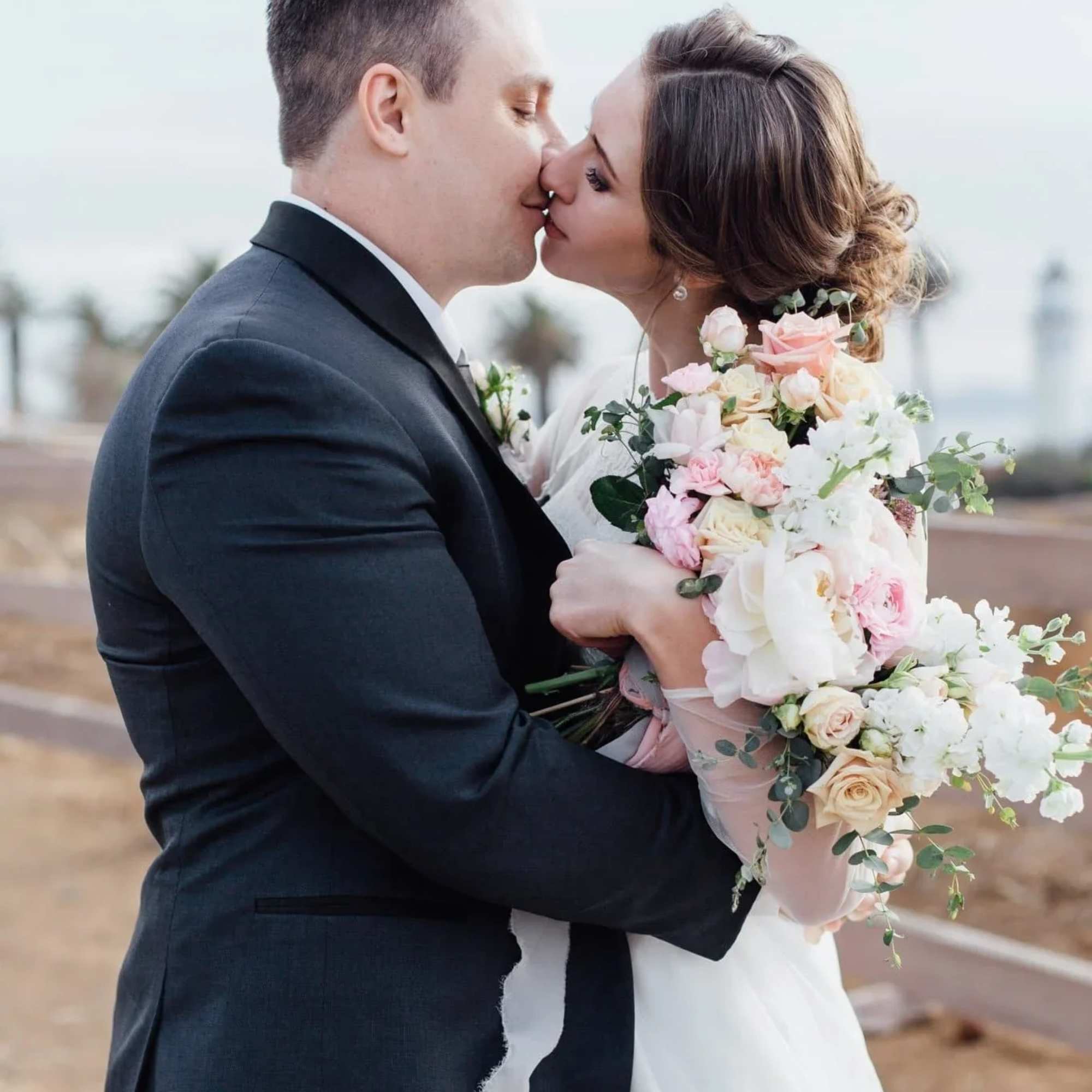 This stunning wedding bouquet features a mix of soft pastel roses, peonies