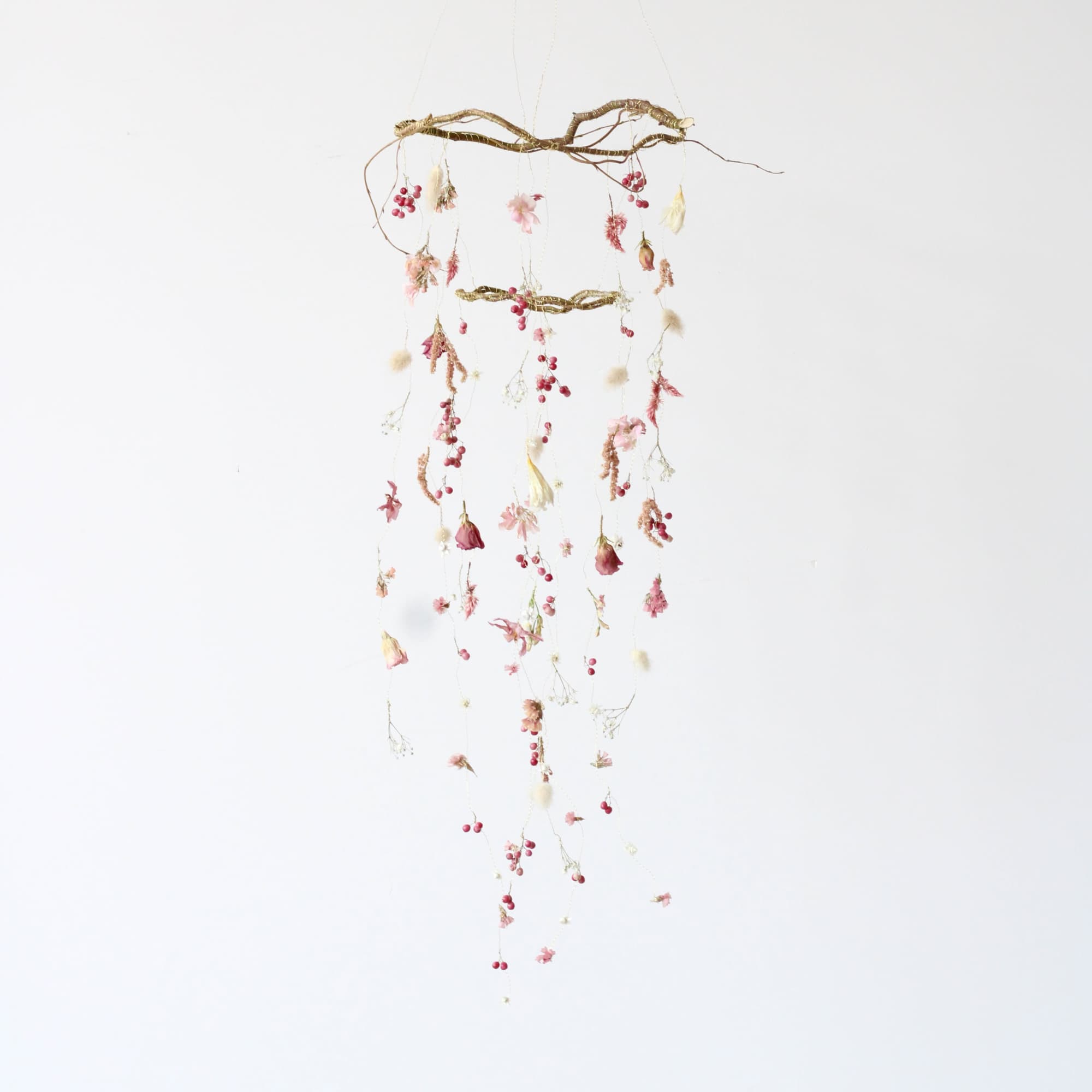 This petite dried floral mobile is a charming, nature-inspired piece that brings