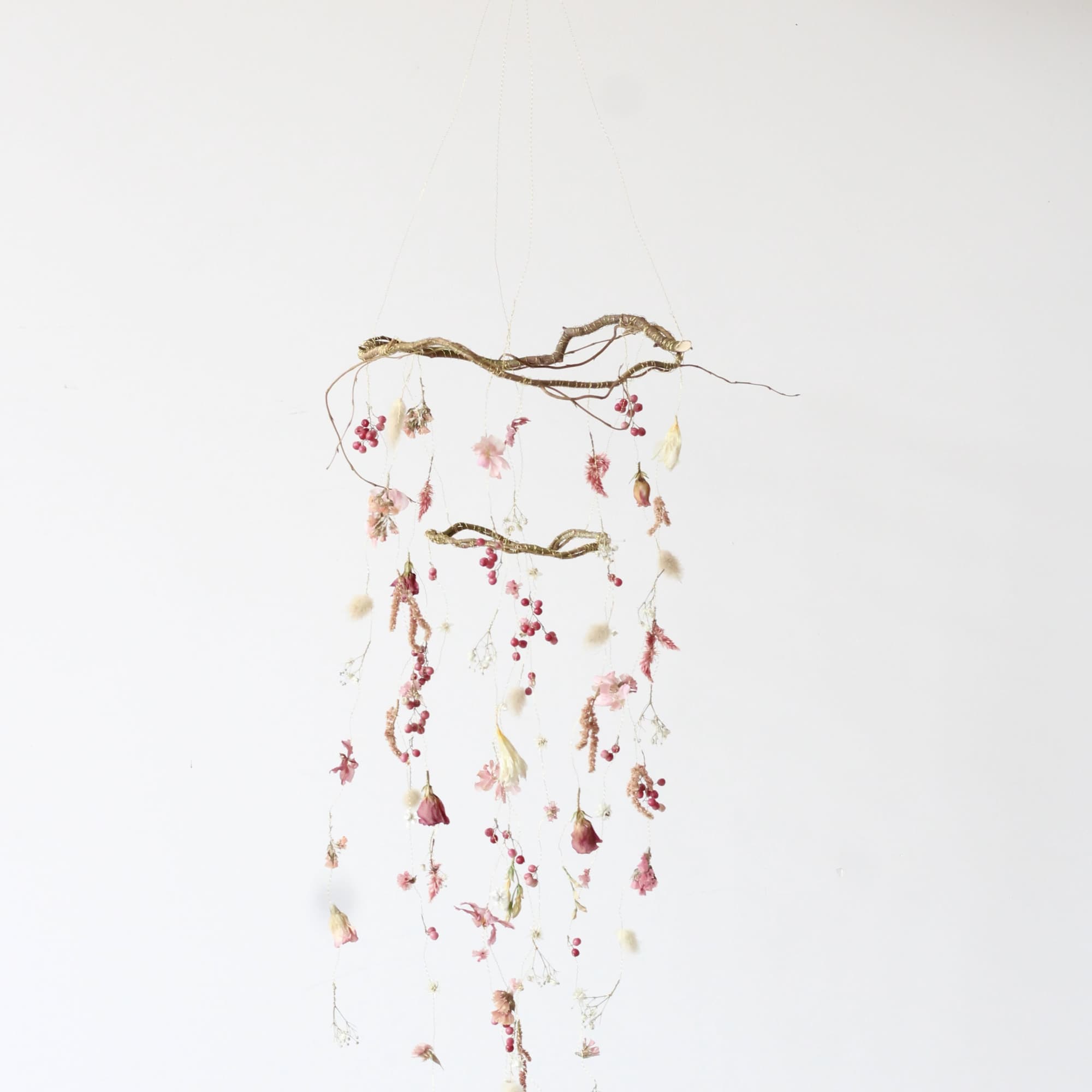 This petite dried floral mobile is a charming, nature-inspired piece that brings
